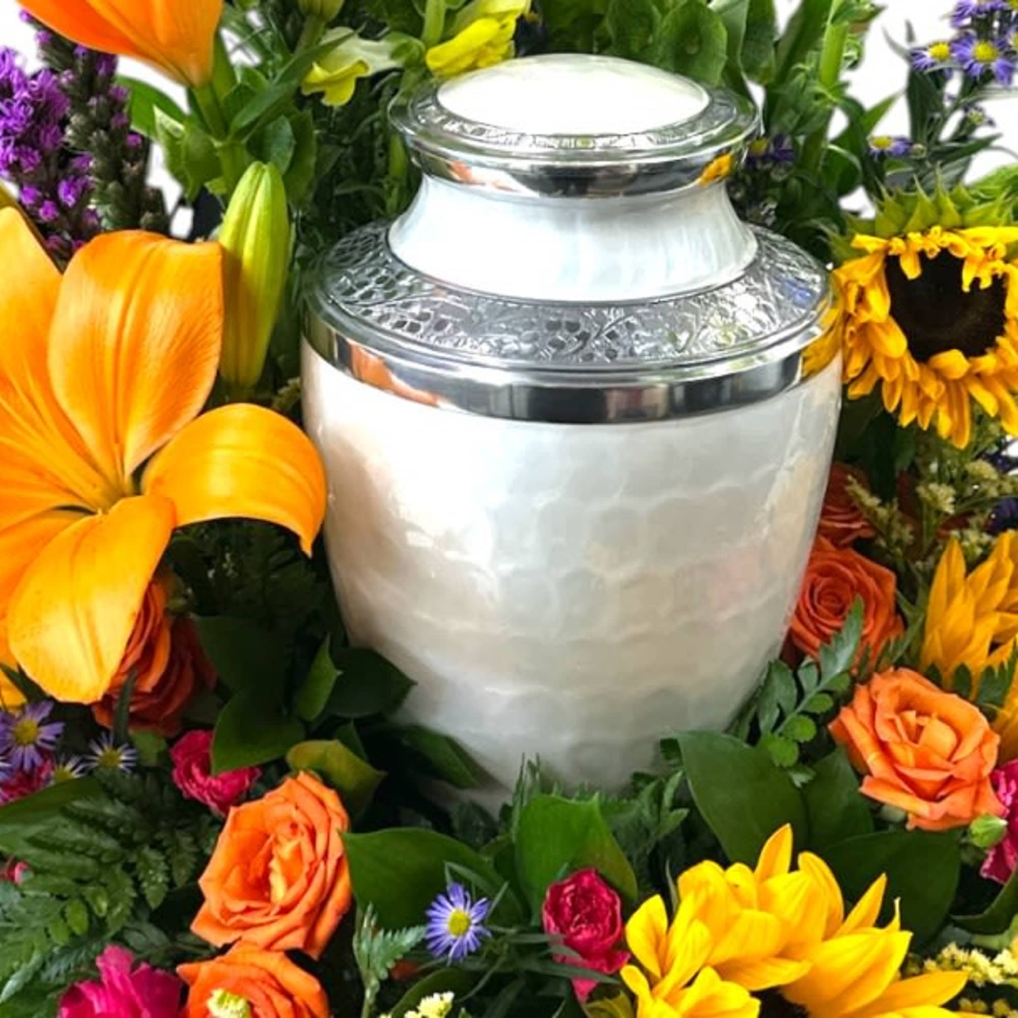 This vibrant floral arrangement features a cheerful mix of sunflowers, orange roses