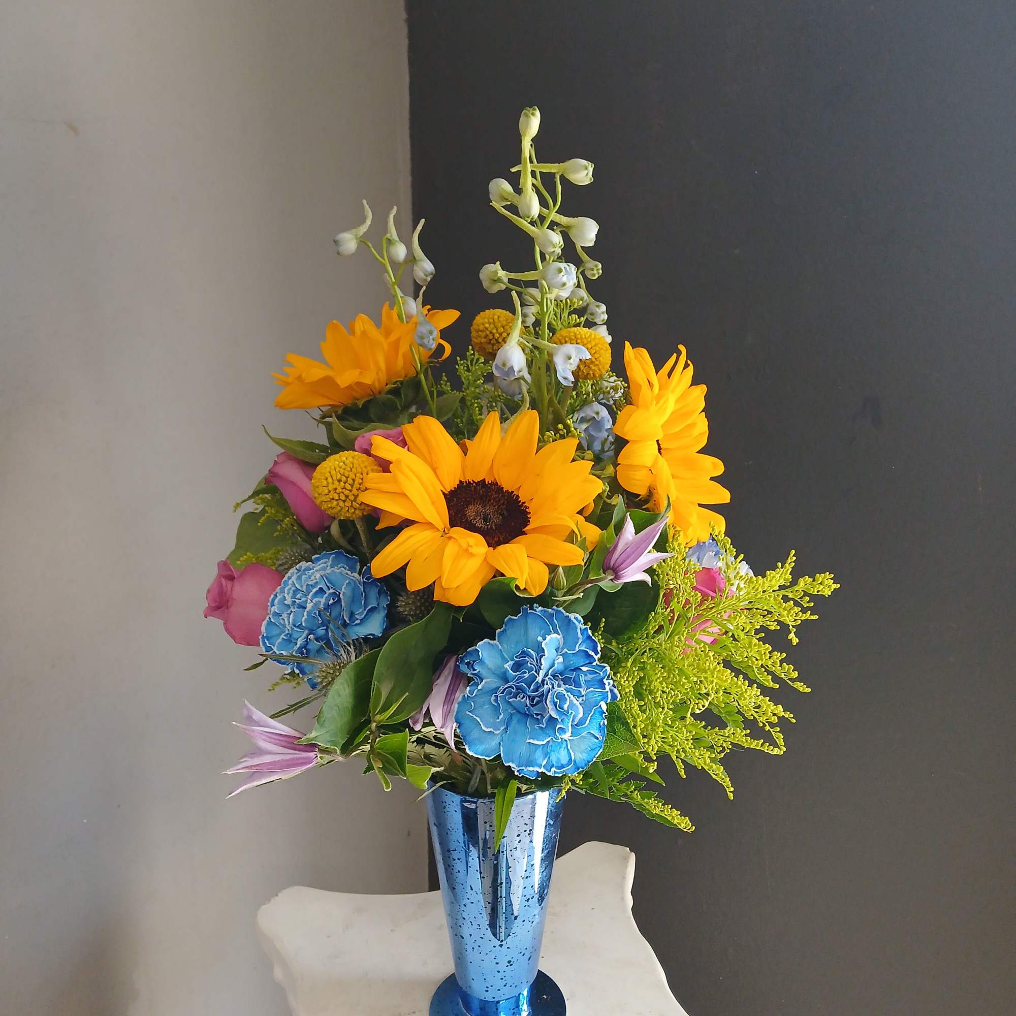 This beautiful flower arrangement of fresh mixed seasonal blooms is made by
