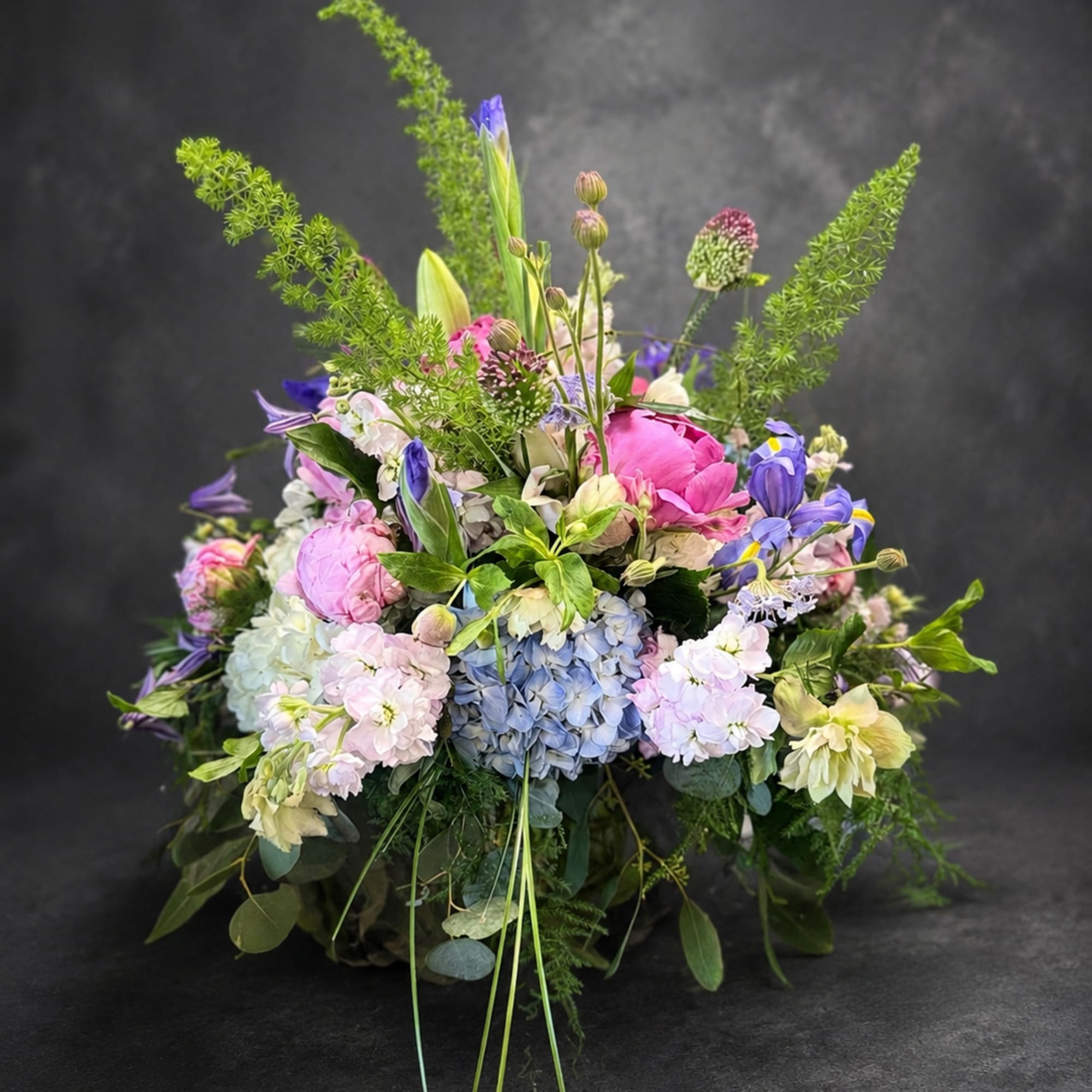 Lush pastel hydrangeas and full pink peonies create an immediate sense of