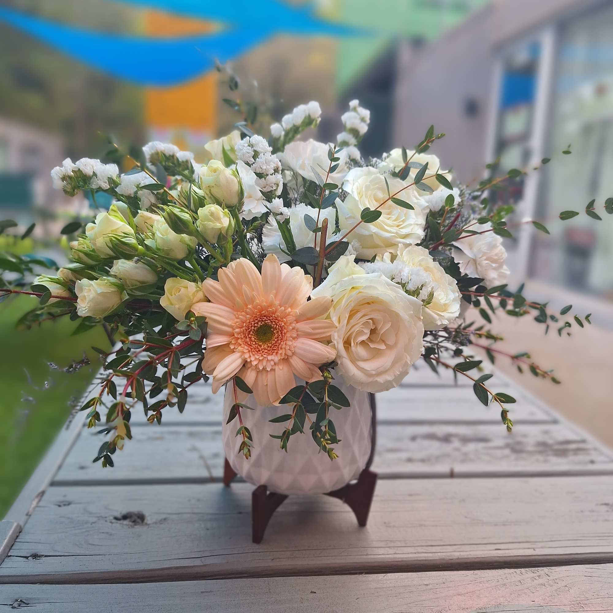 Peach gerbera and white roses in a pink vase