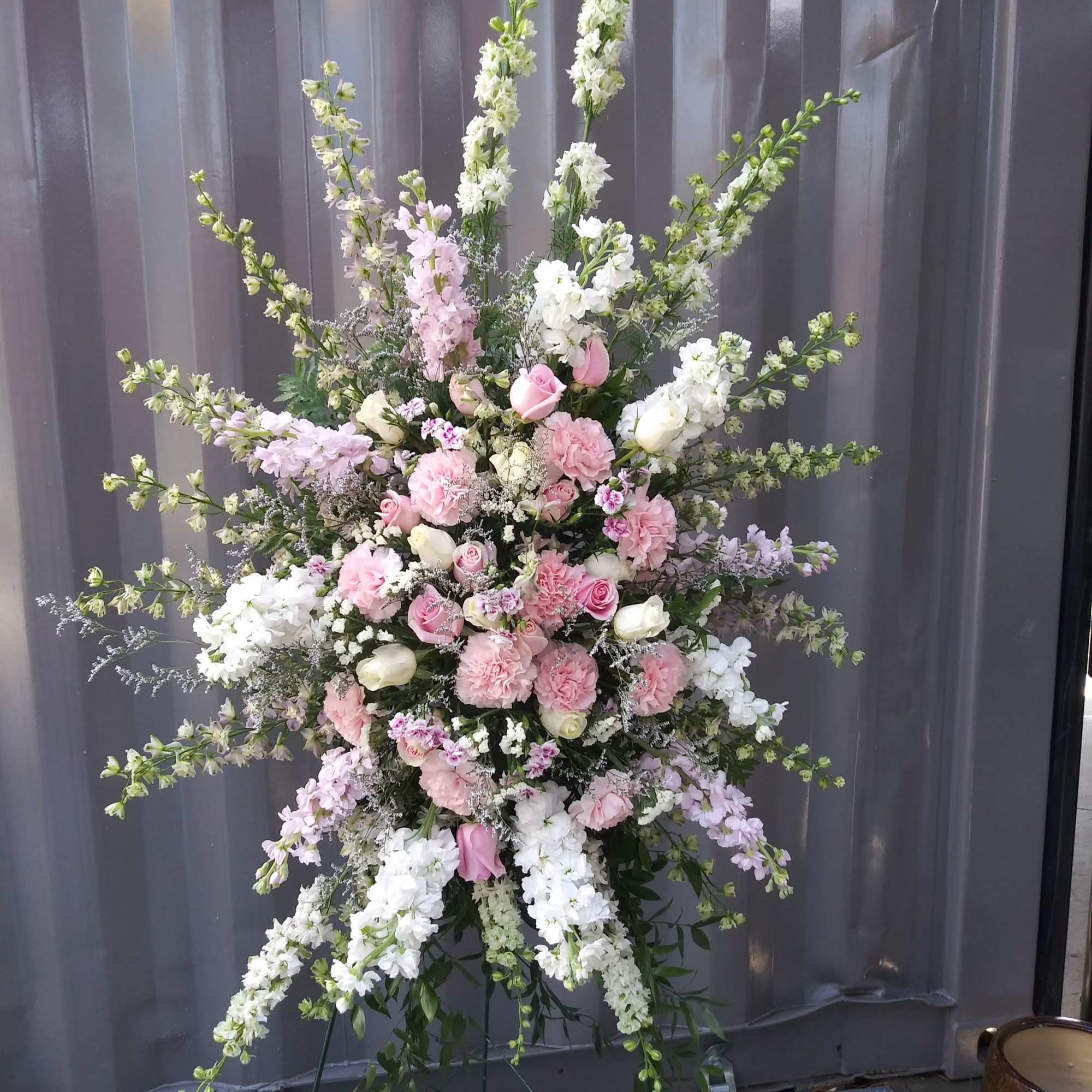 Tall pink and white floral standing spray on an easel
