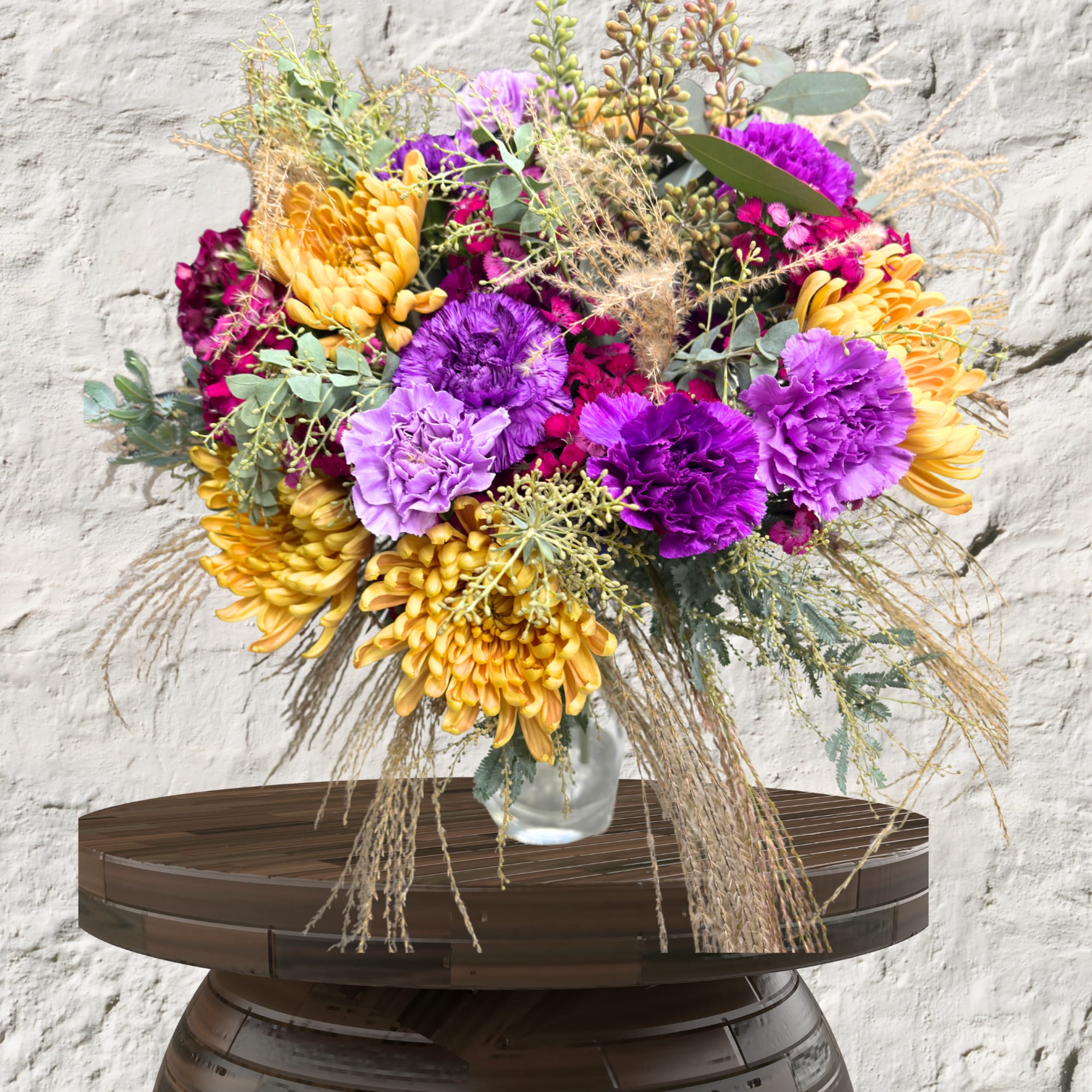 Bouquet of purple and yellow flowers in a glass vase