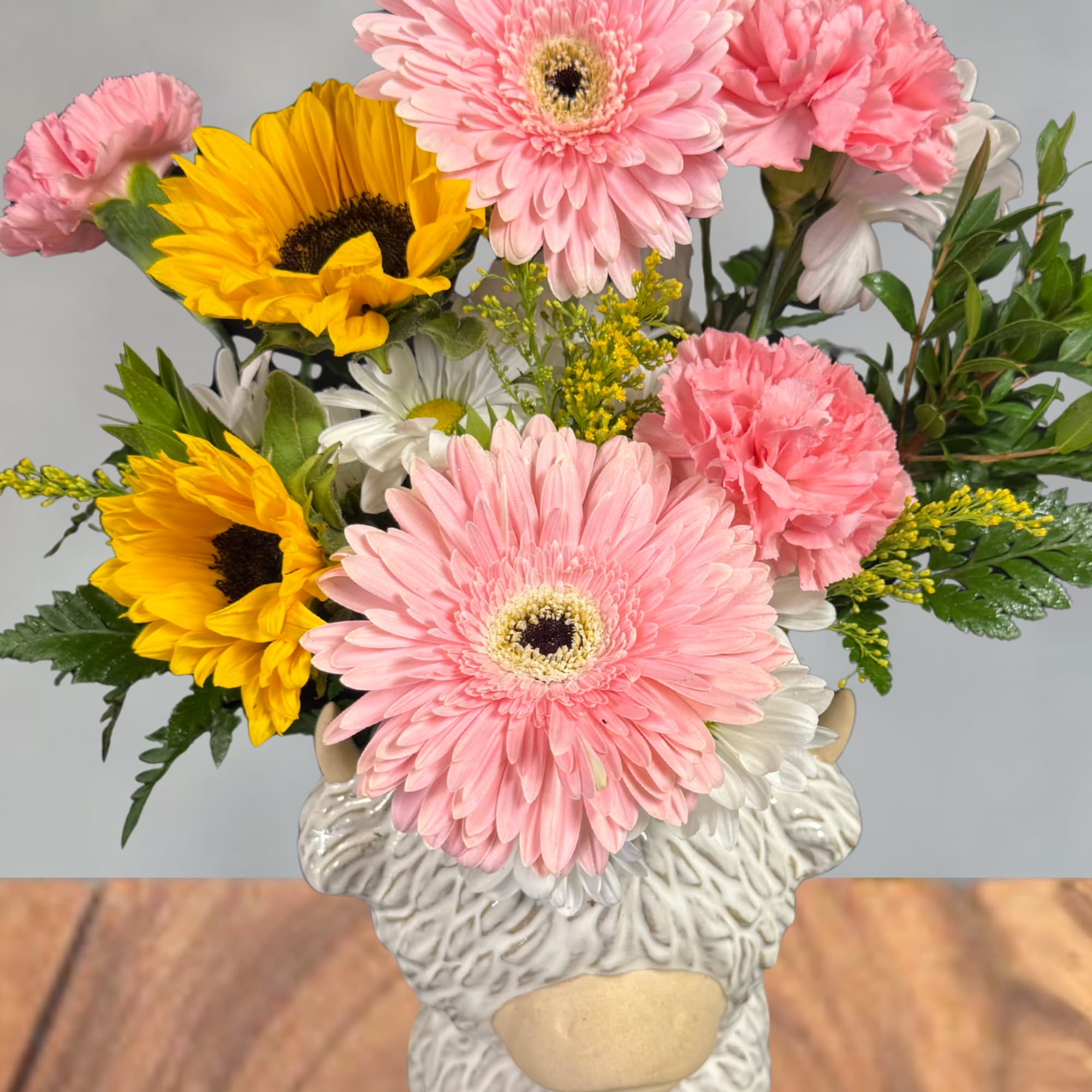 Bright, playful and impossible to miss, this Highland cow flower arrangement is