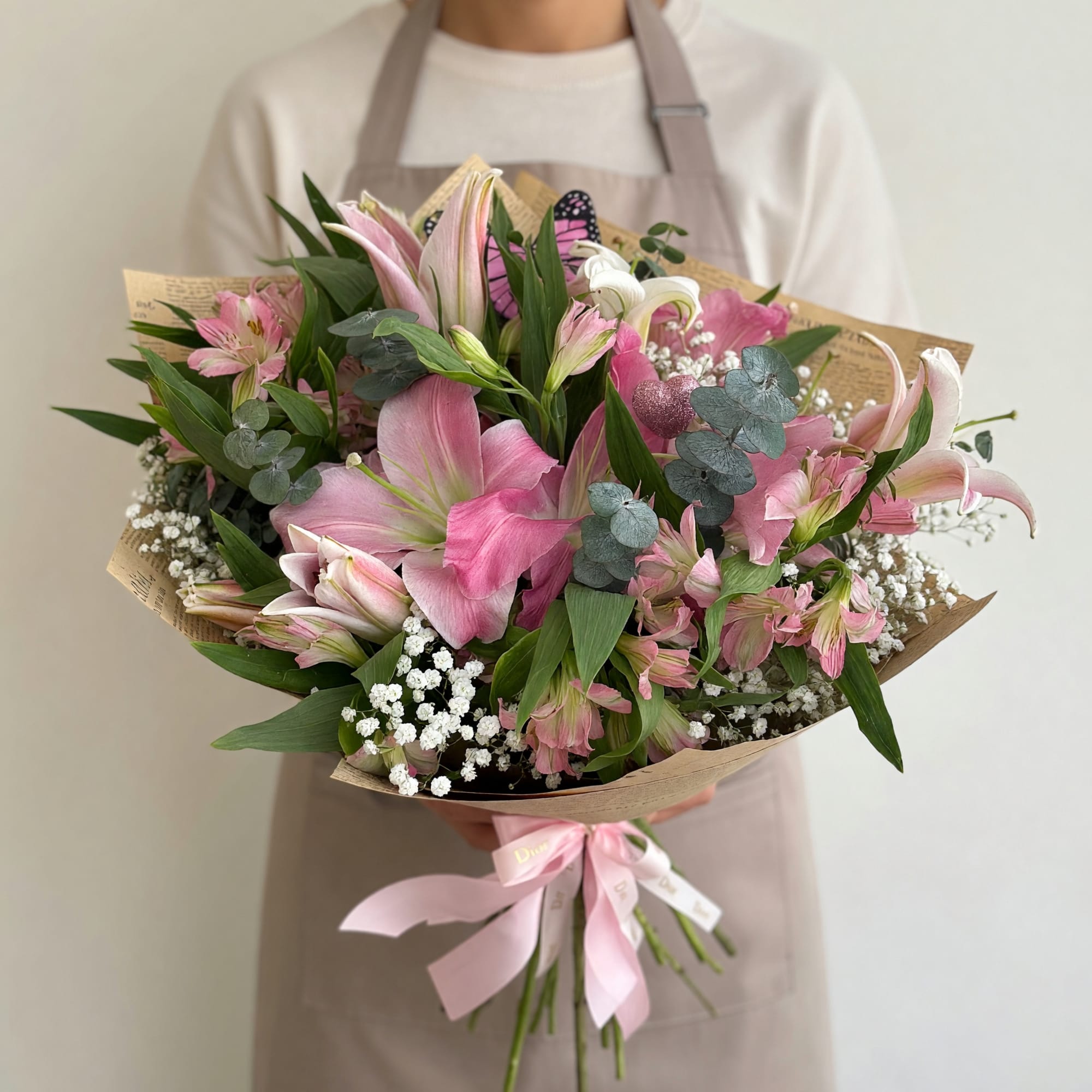 Large pink and white lilies mingle with delicate pink alstroemeria and cloud-like