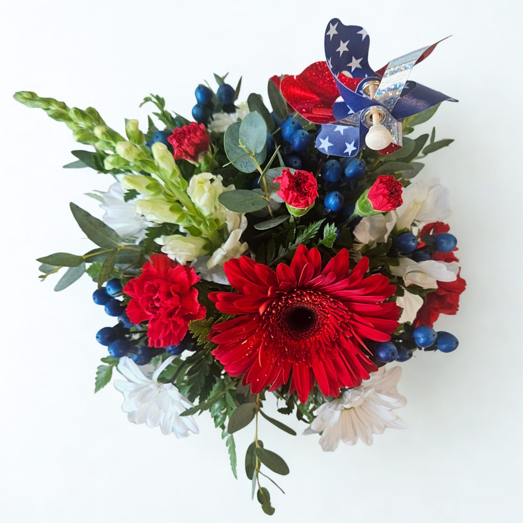Small Red, White and Blue arrangement in a blue square vase. Features