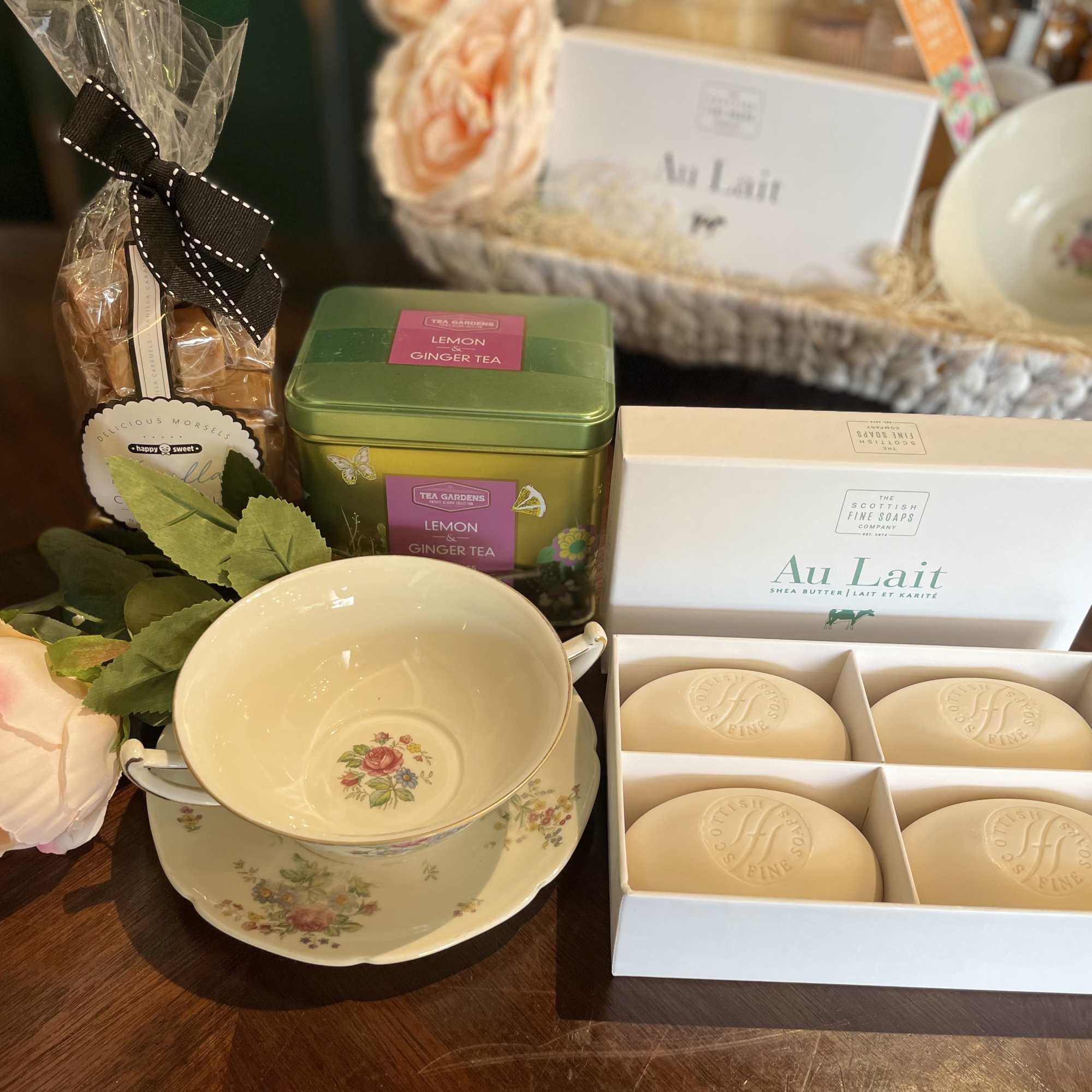 Gift basket with tea, soap, a teacup set, and a pink rose