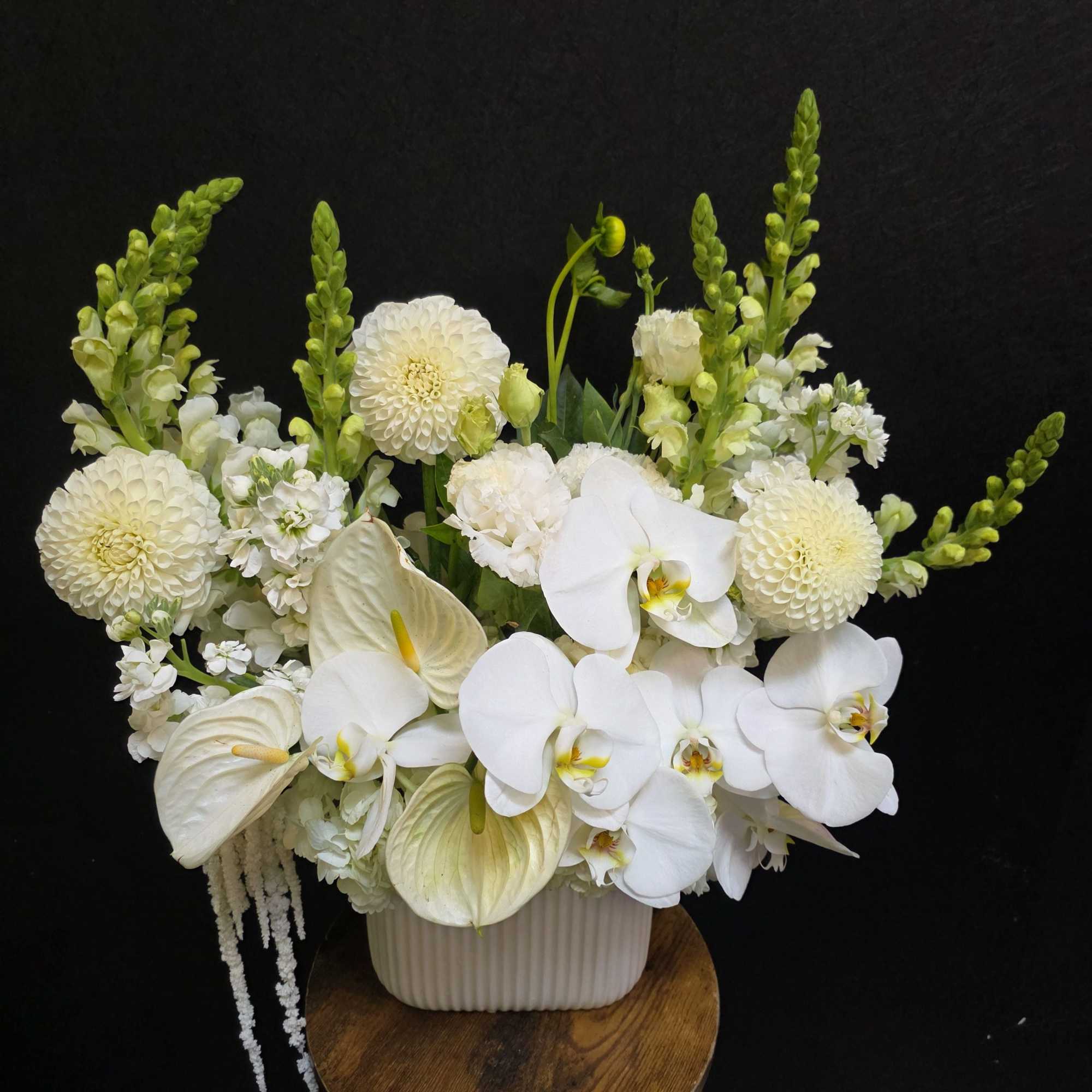 A serene sculptural display of white blooms, Angel's Embrace is a formal