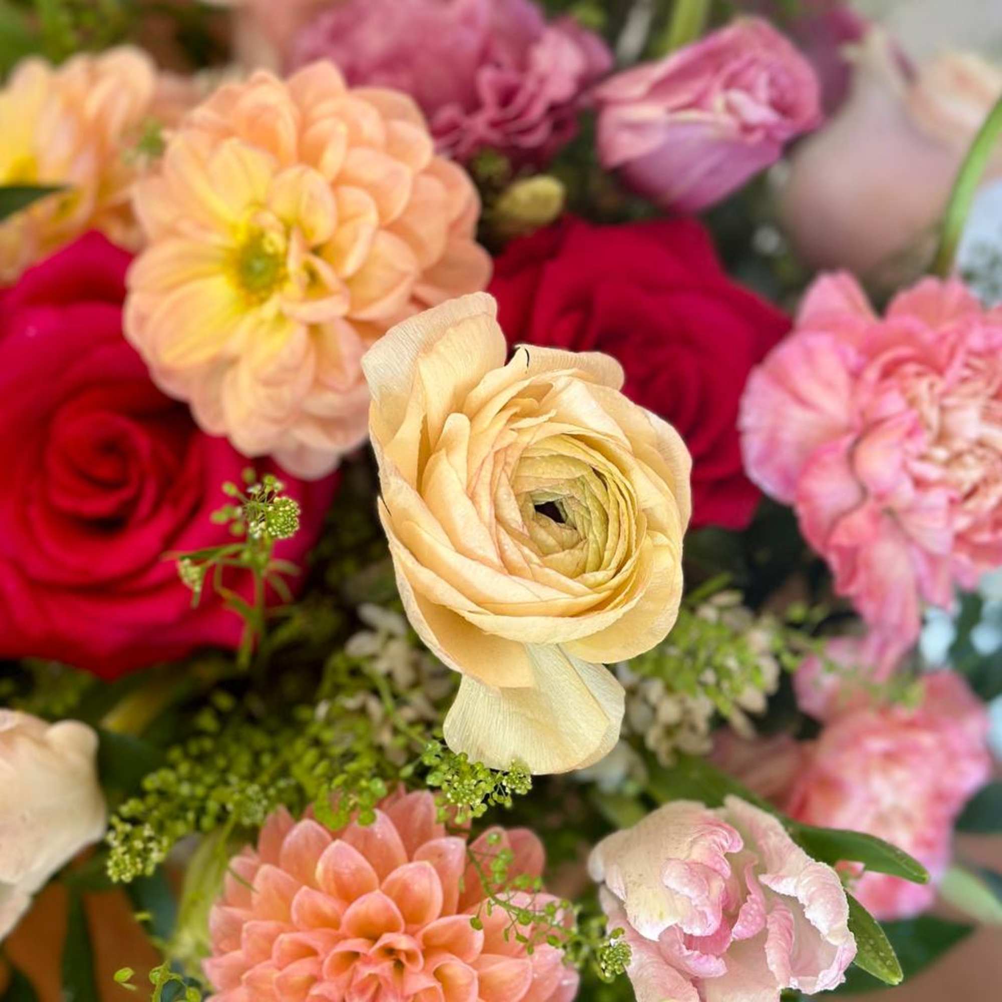 Mixed bouquet with roses, dahlias, and ranunculus in pink, peach, and cream