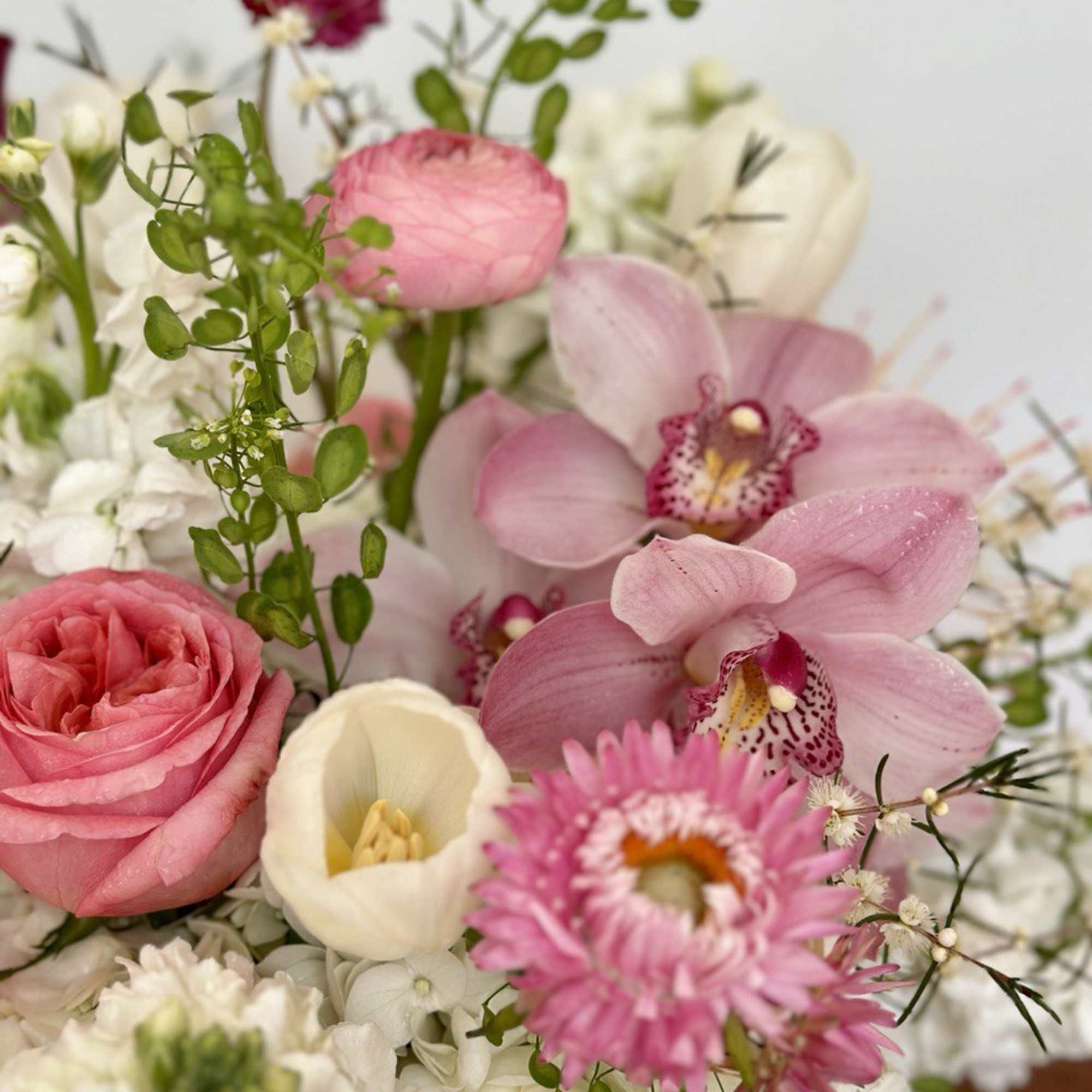 Pink and white mixed bouquet with orchids, roses, and daisies