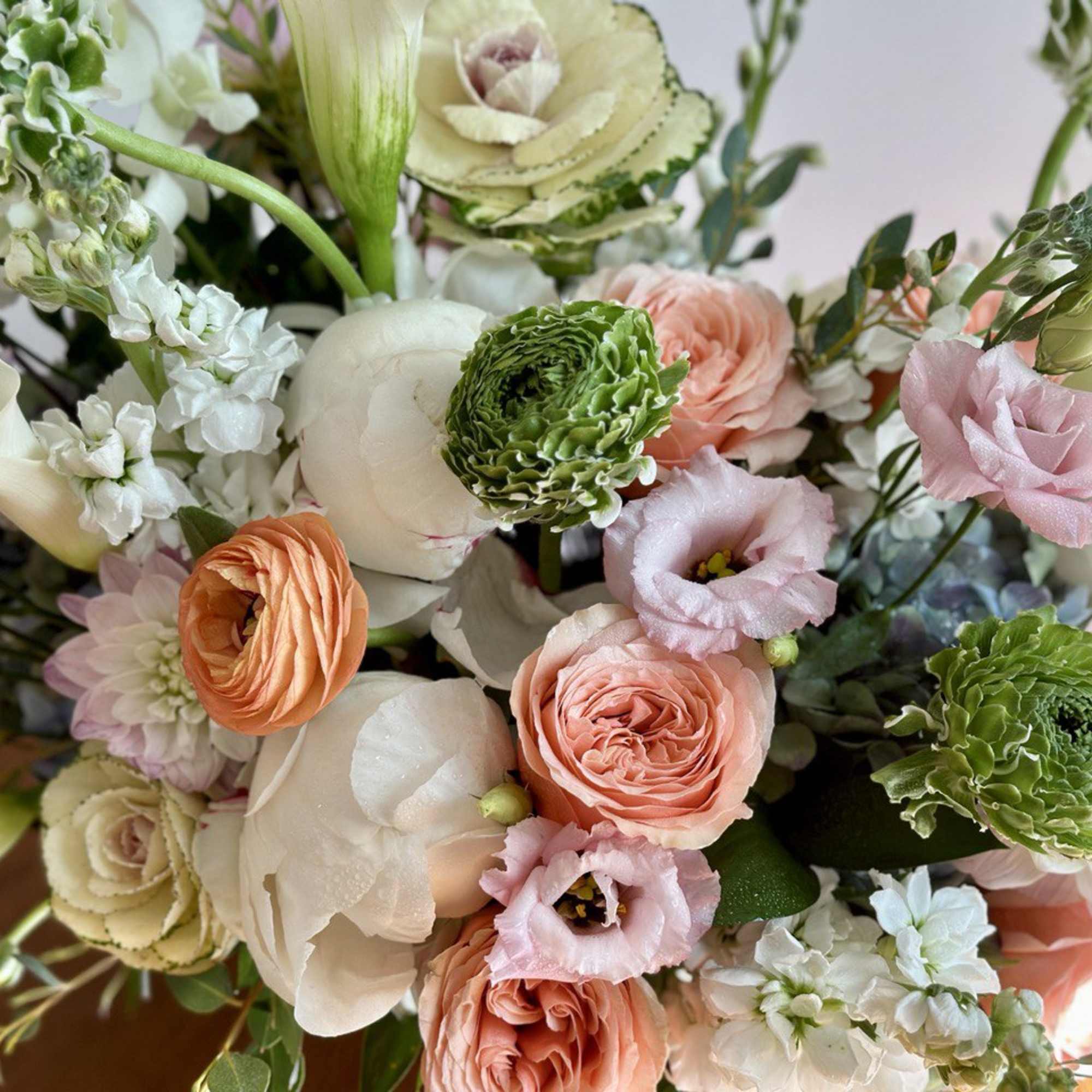 Pastel bouquet with peach, pink, white, and green flowers