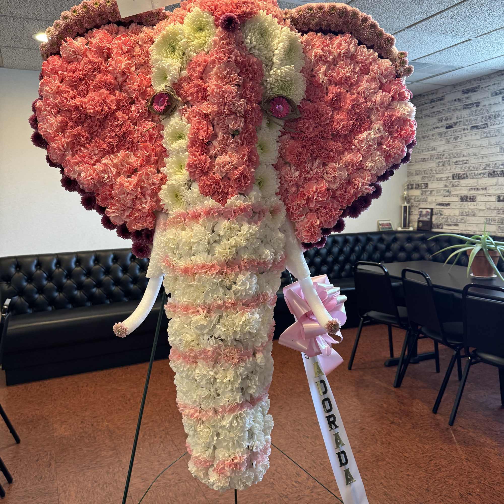 Large elephant-shaped floral display made of pink and white carnations