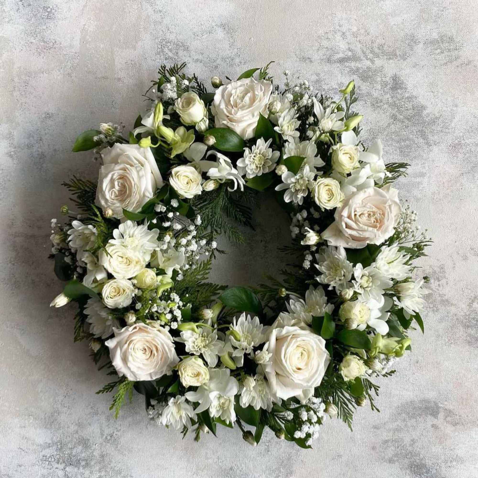 White floral wreath with roses and small white blooms