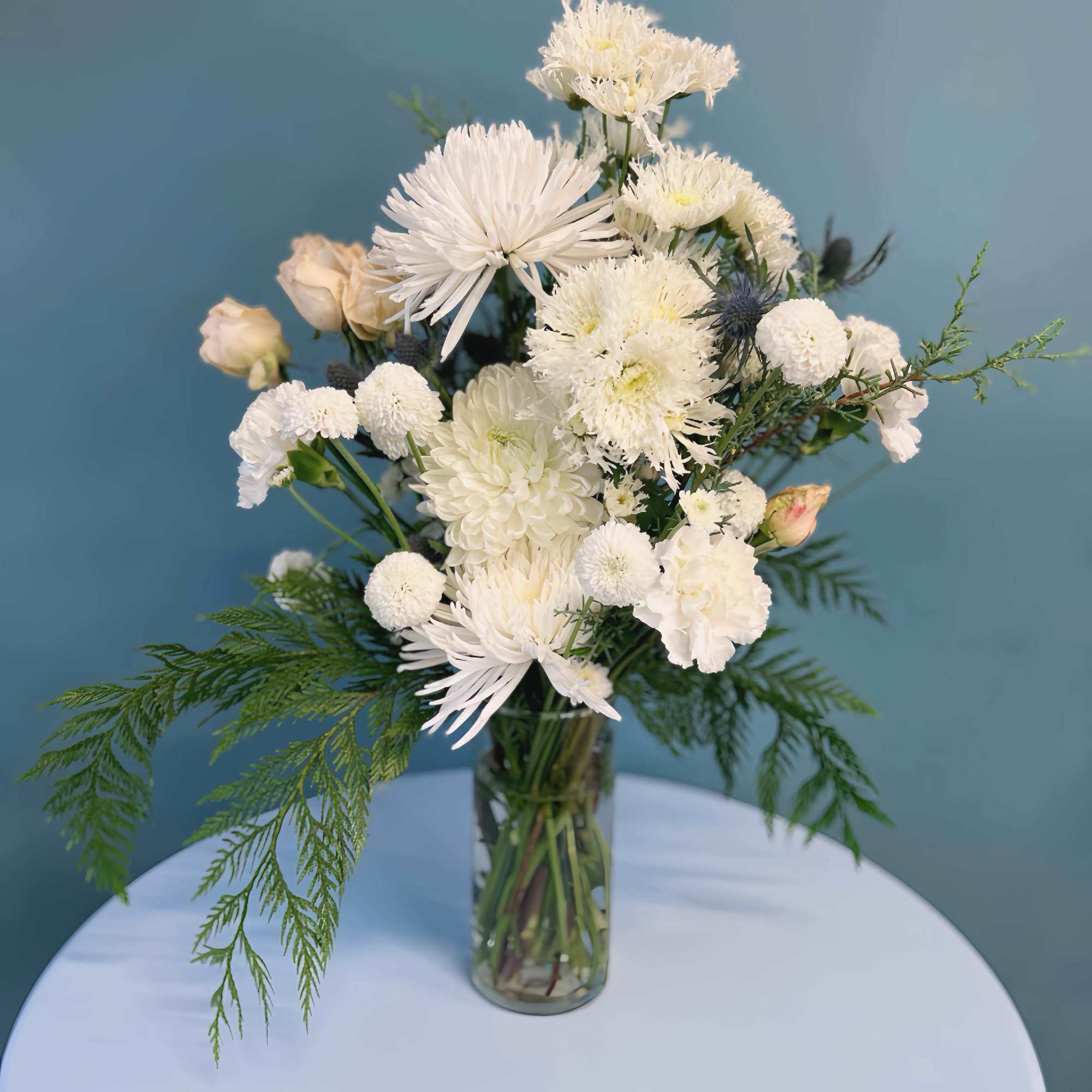 White mixed flower arrangement in a clear glass vase