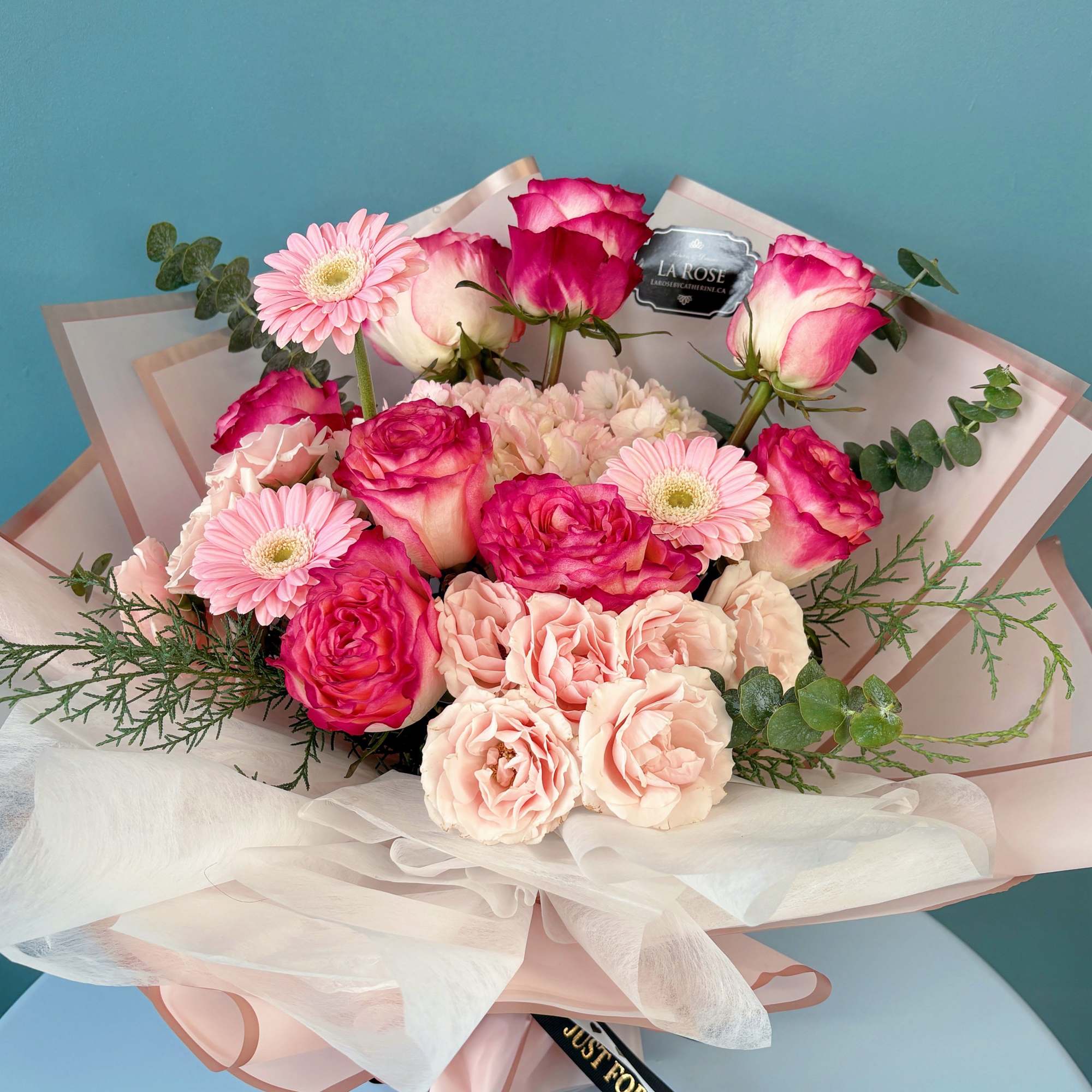 Pink and white rose bouquet with gerbera daisies and wrapping paper