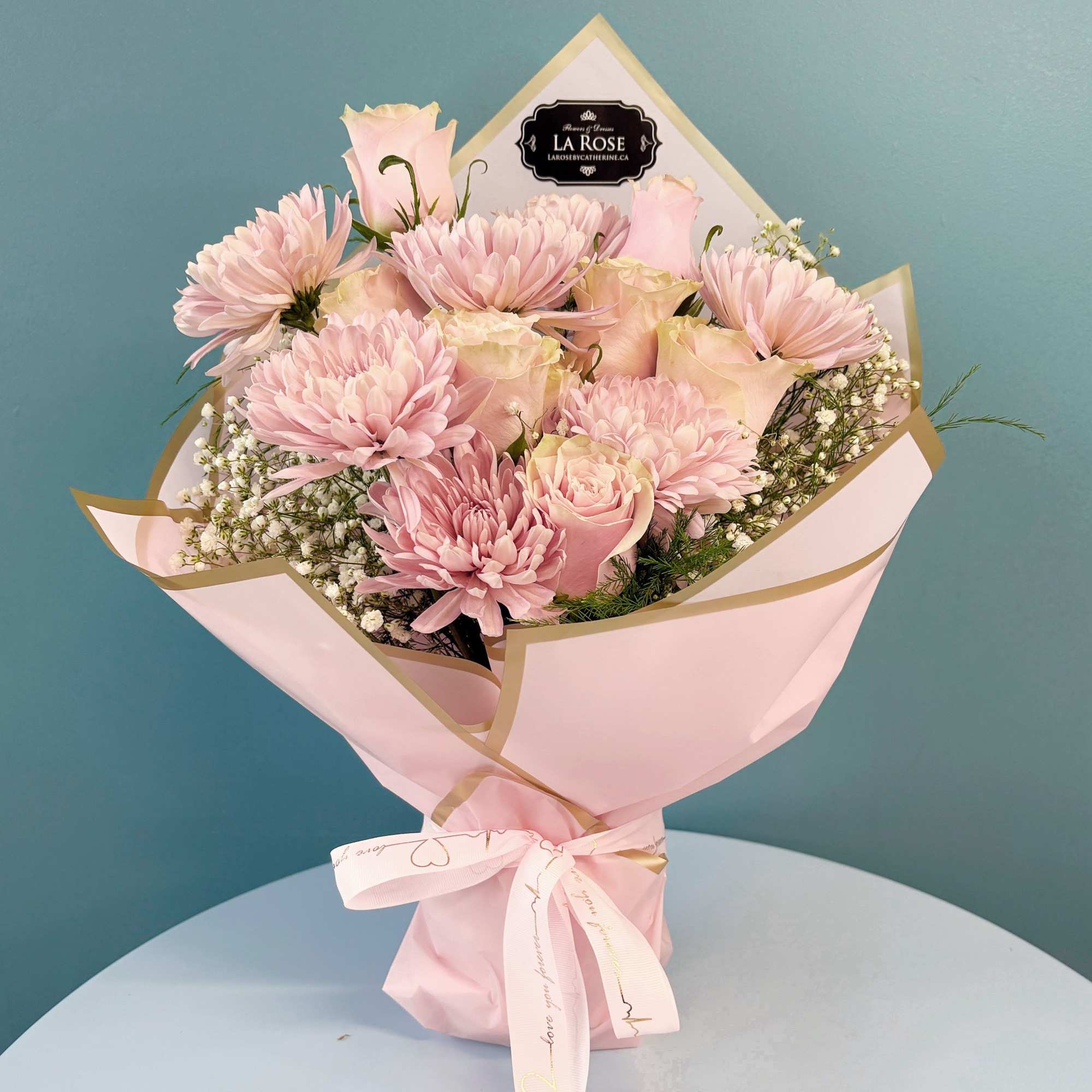 Pink bouquet of roses and chrysanthemums wrapped in pastel paper