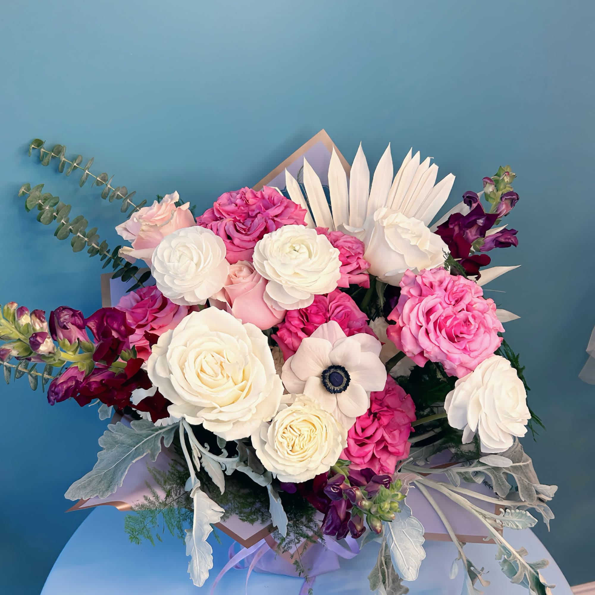 Bouquet of pink and white roses with purple flowers and pale foliage