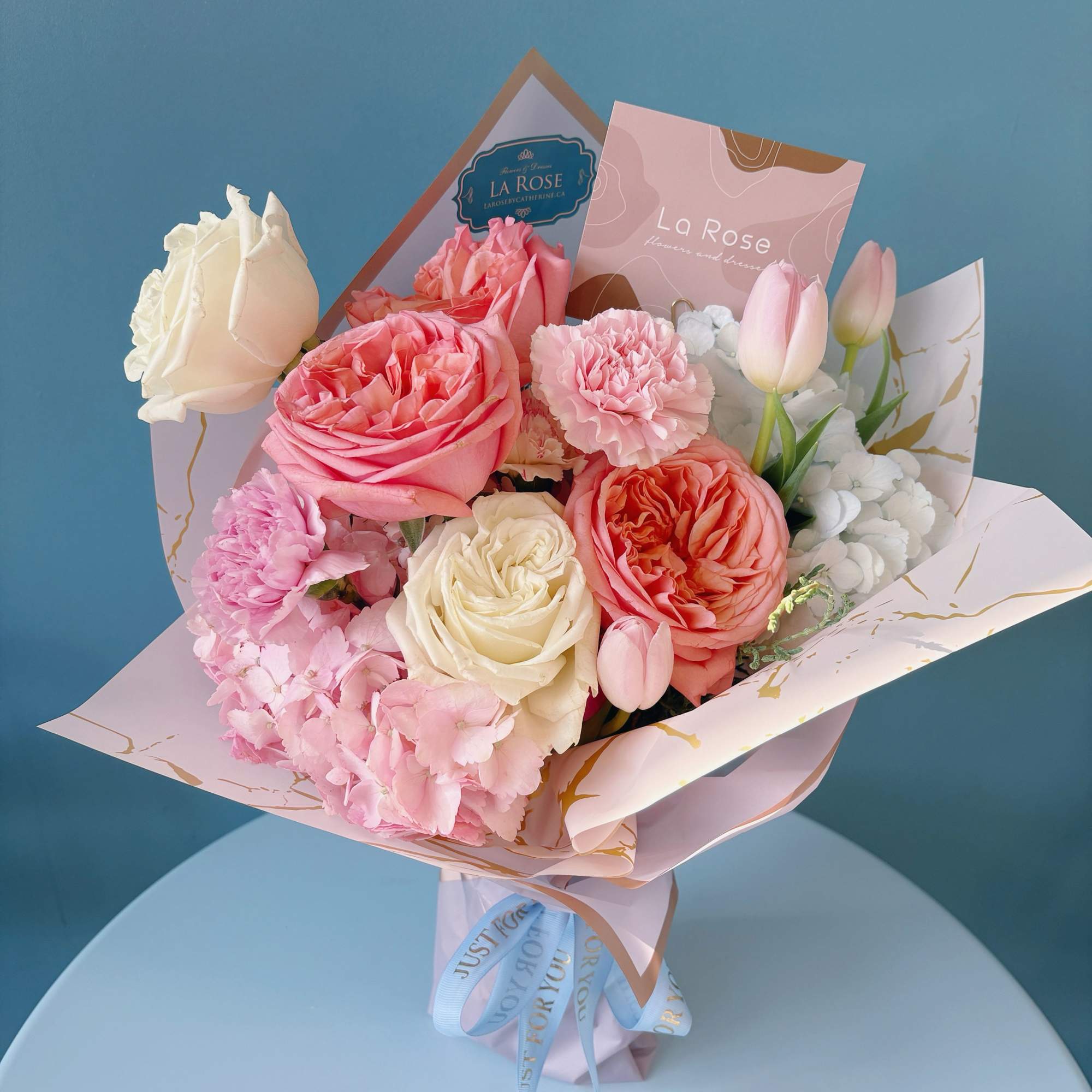 Pink and white rose bouquet with tulips and carnations in pastel wrap