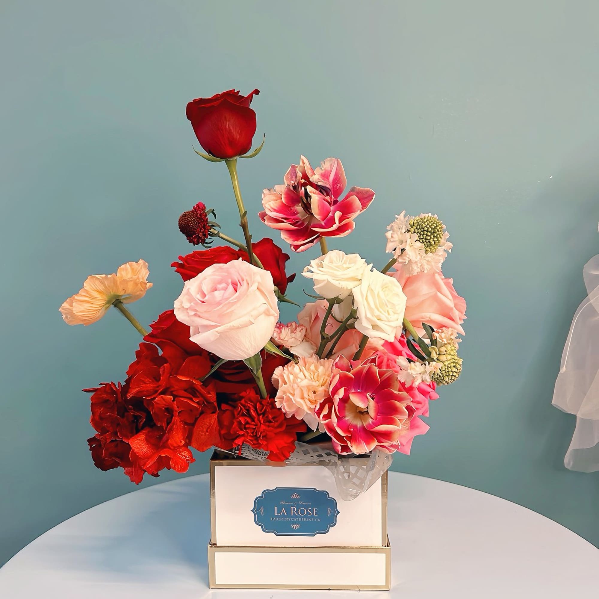 Mixed bouquet of red, pink, and white roses in a square box
