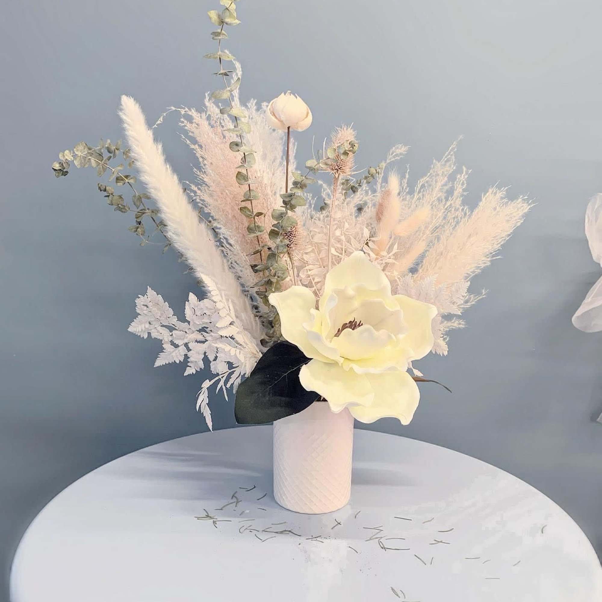 Cream floral arrangement in a white vase with airy dried accents