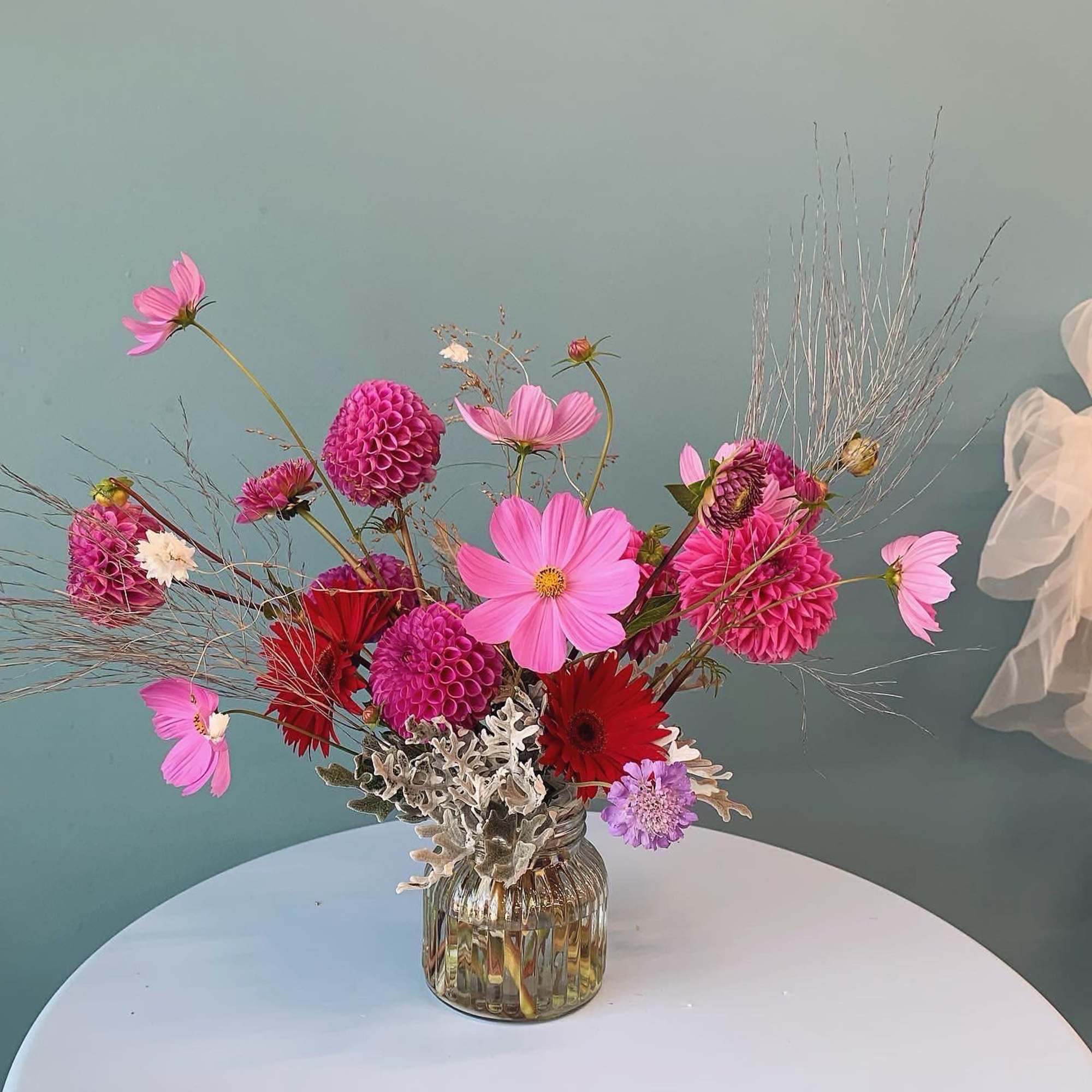 Pink and red mixed flower arrangement in a glass vase