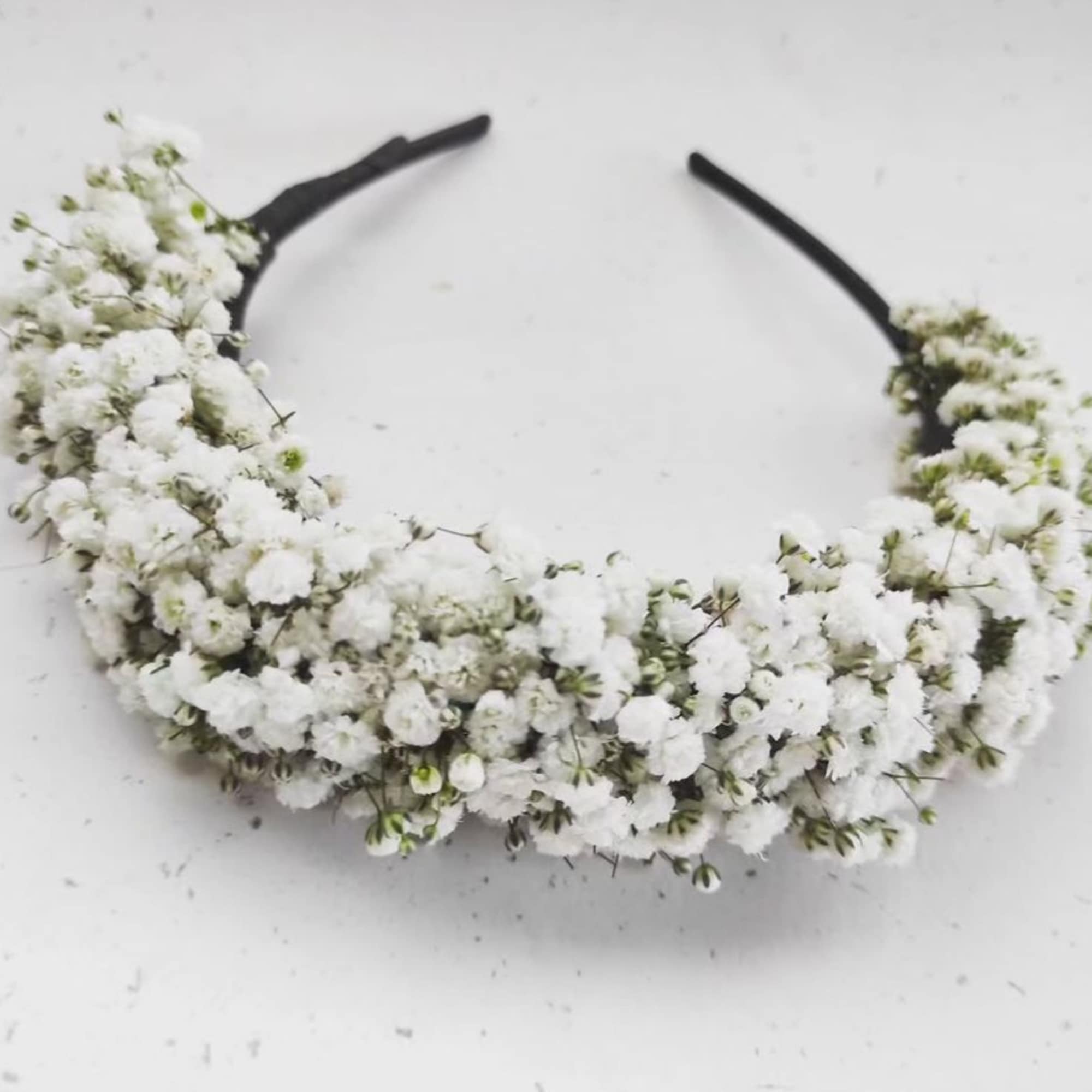 White floral headband with clustered tiny blossoms on a black band