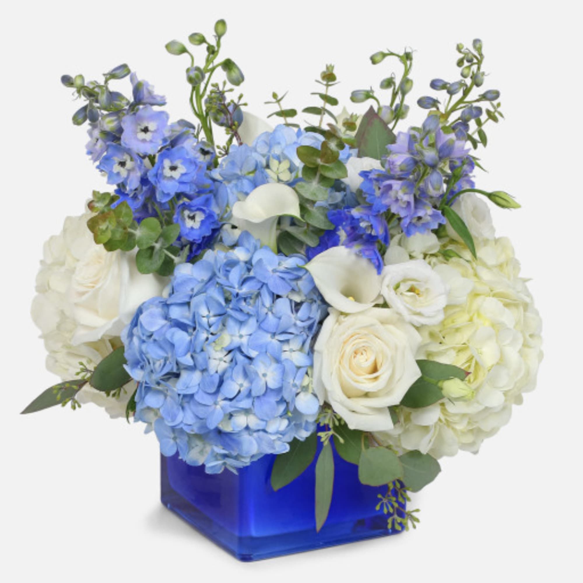 Blue and white floral arrangement in a cobalt square vase