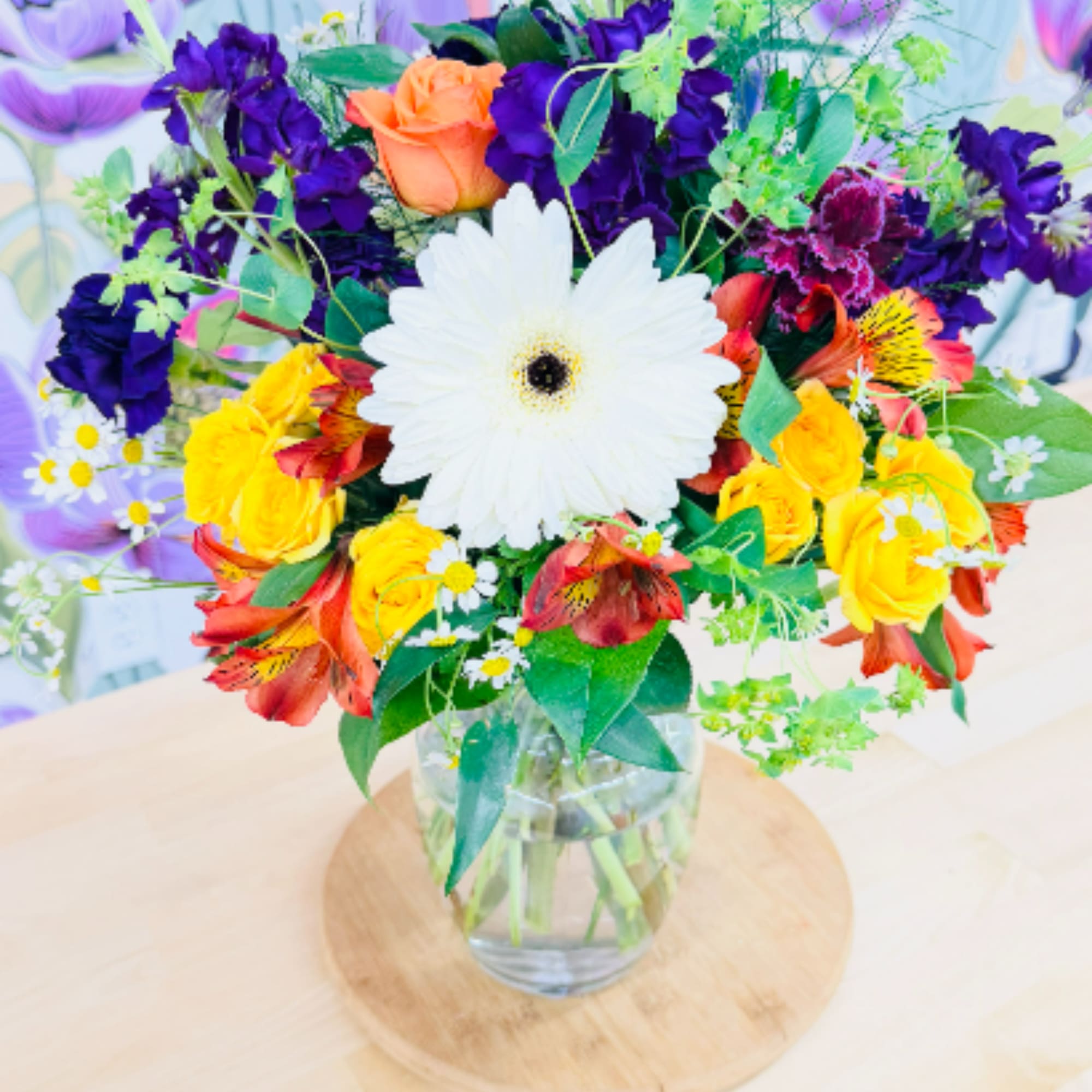 A bright 'star of the show' gerbera daisy (color may vary) crowns
