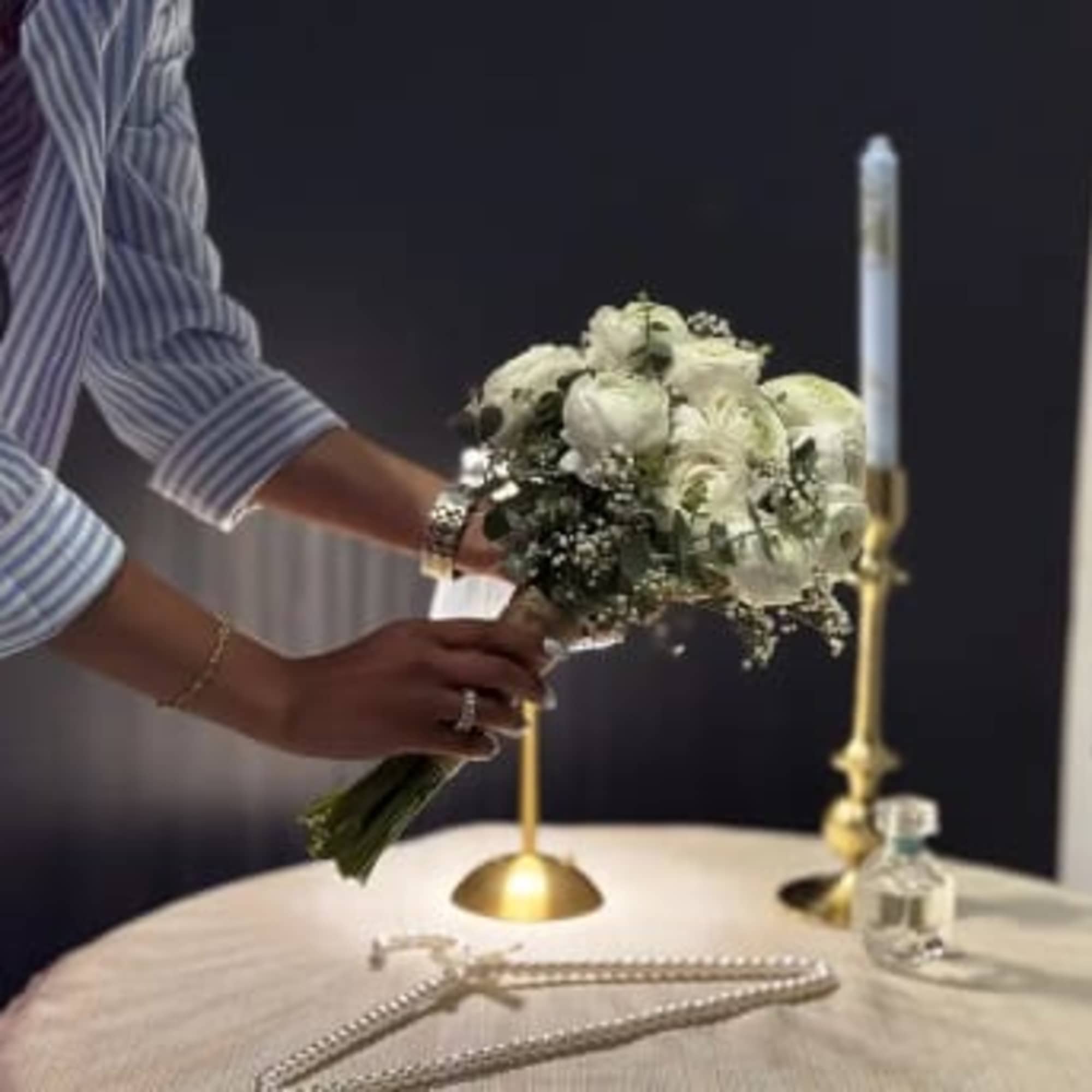White bridal bouquet with round blooms held over a table