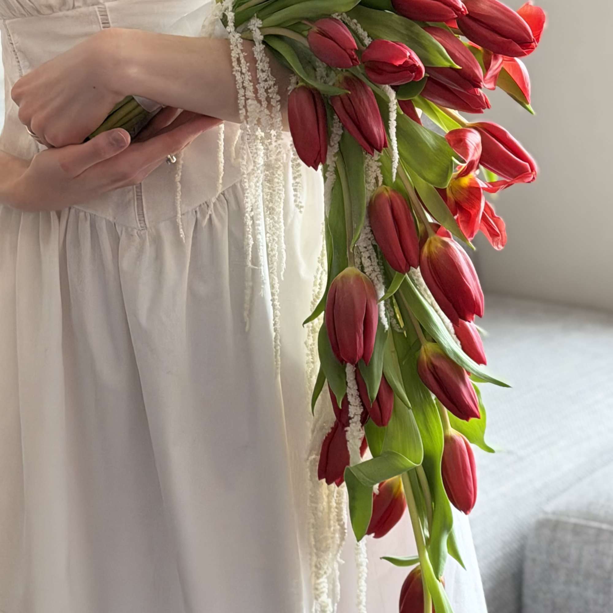 A dramatic cascade of deep red tulips-this bridal bouquet brings bold romance