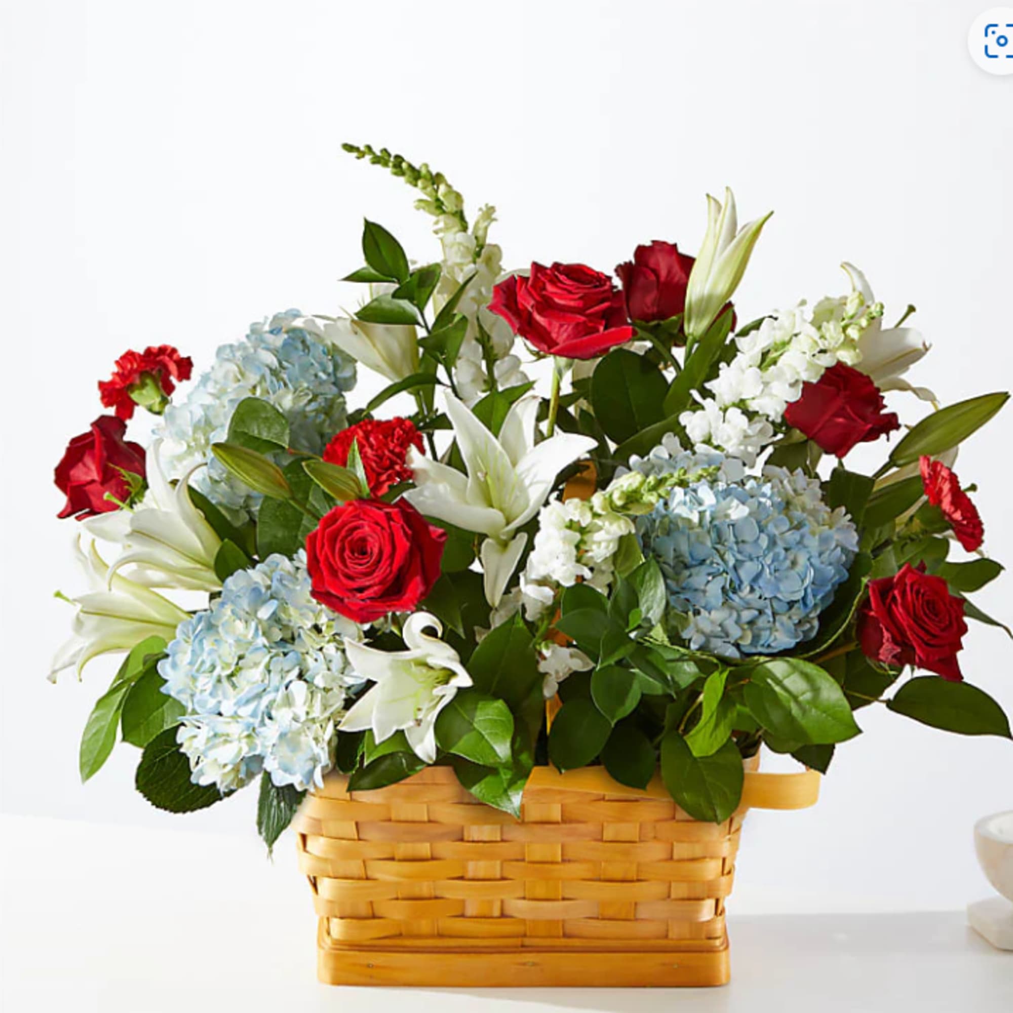 This arrangement a patriotic display of blue, red and white florals. Whether