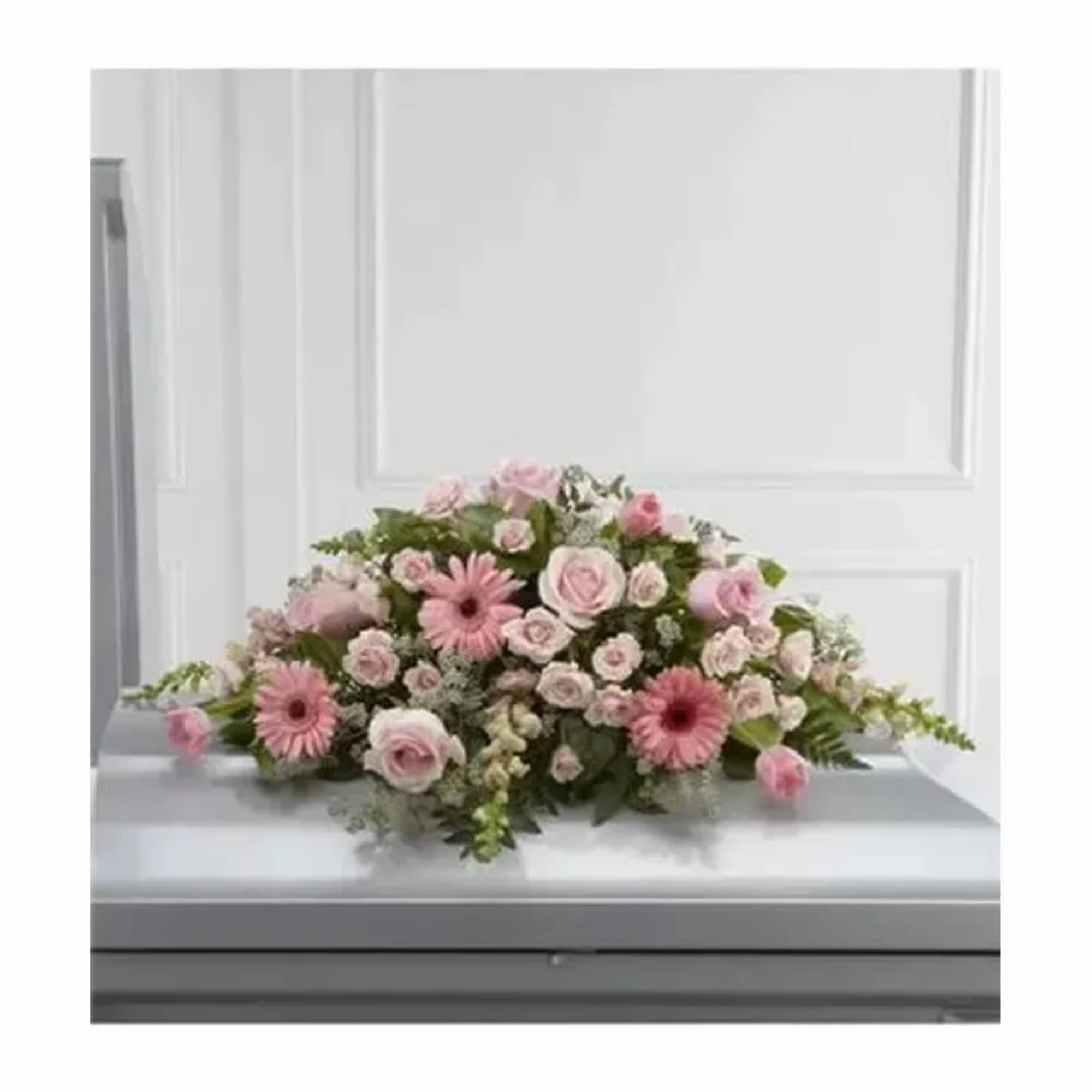 Blushing pink roses, gerbera daisies, spray roses, tulips and snapdragons are offset