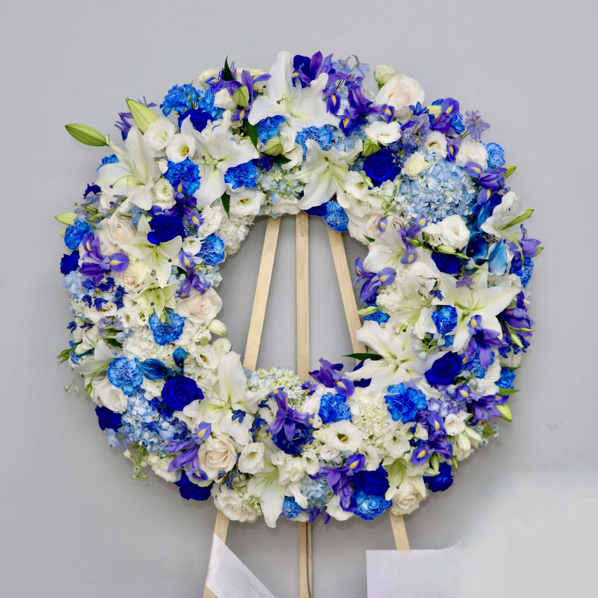This wreath is made with white roses and a variety of blue