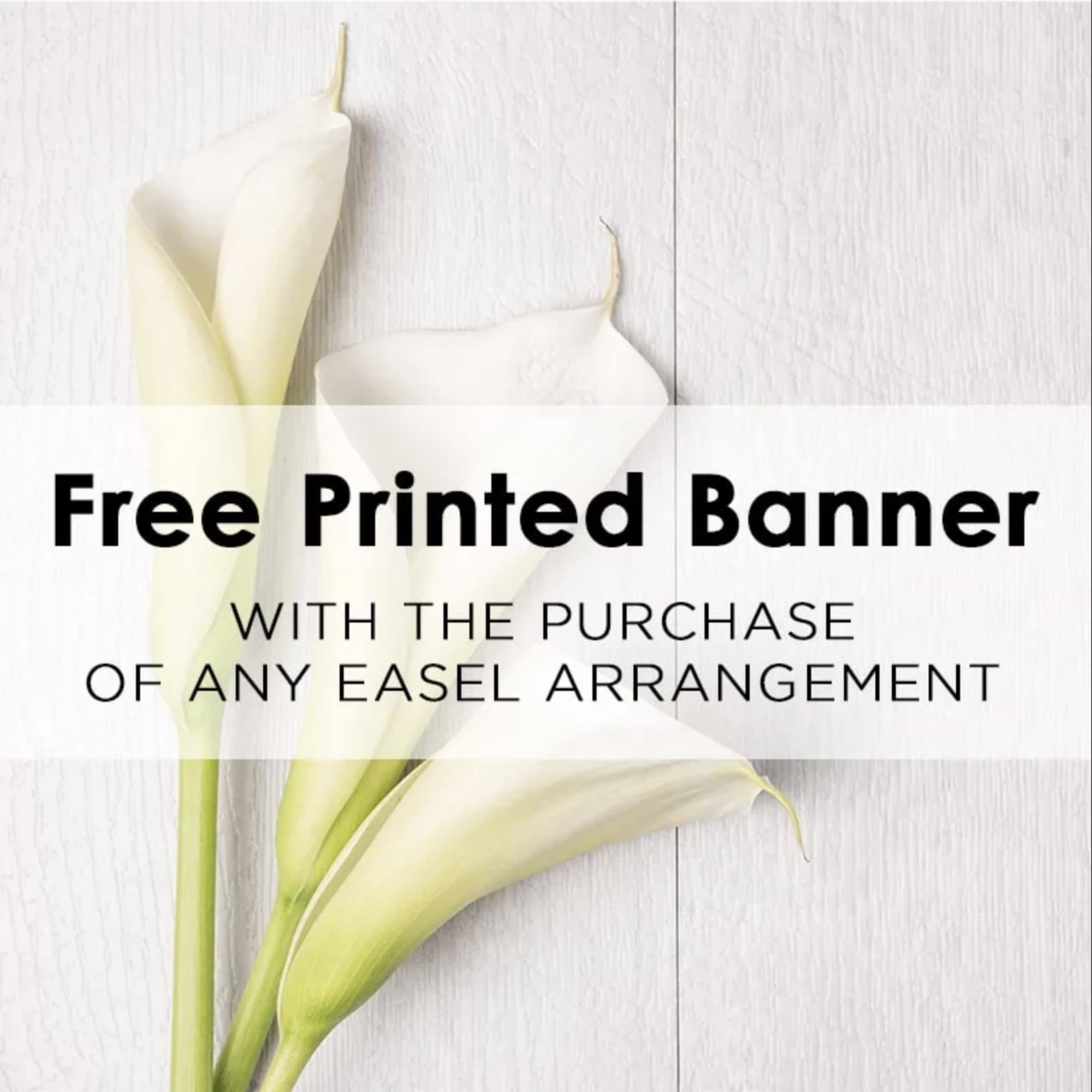 White calla lilies beside a printed banner with text
