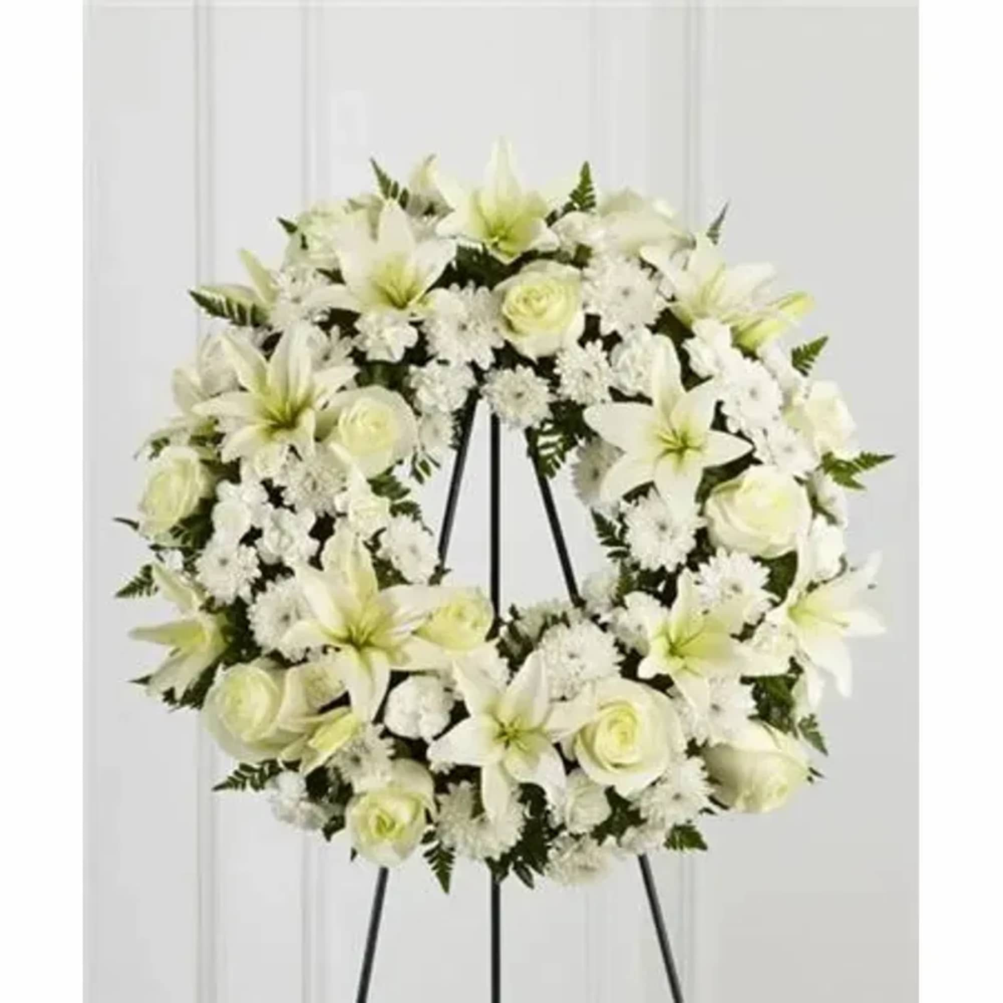 Bright white roses, Asiatic lilies, mini carnations and cushion poms are beautifully