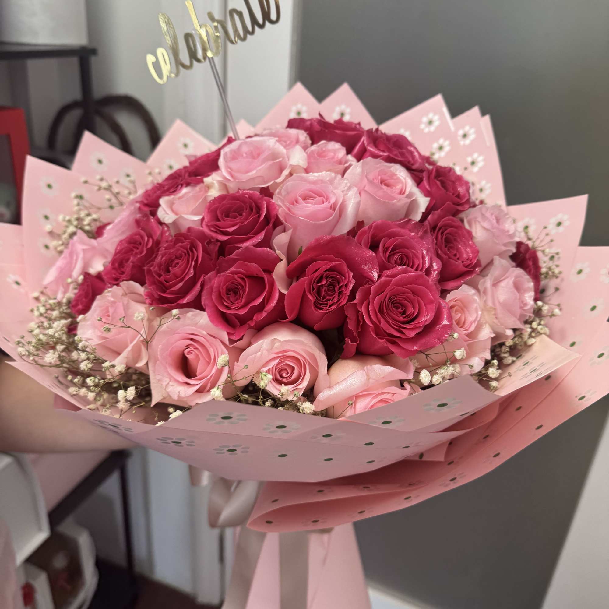 Bouquet of pink and hot pink roses wrapped in pink paper