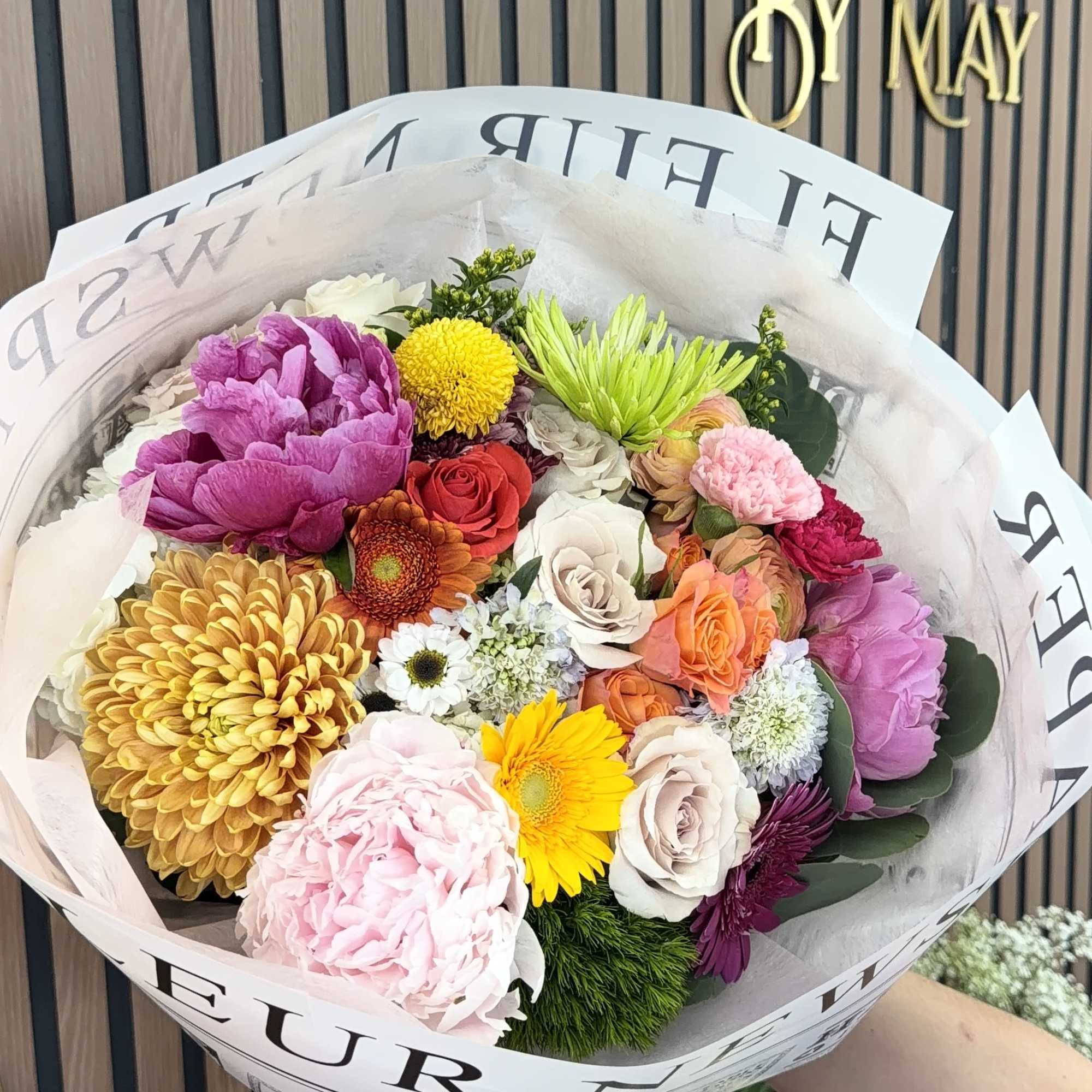 A rounded, hand-tied bouquet bursting with cheerful color-perfect as a birthday bouquet