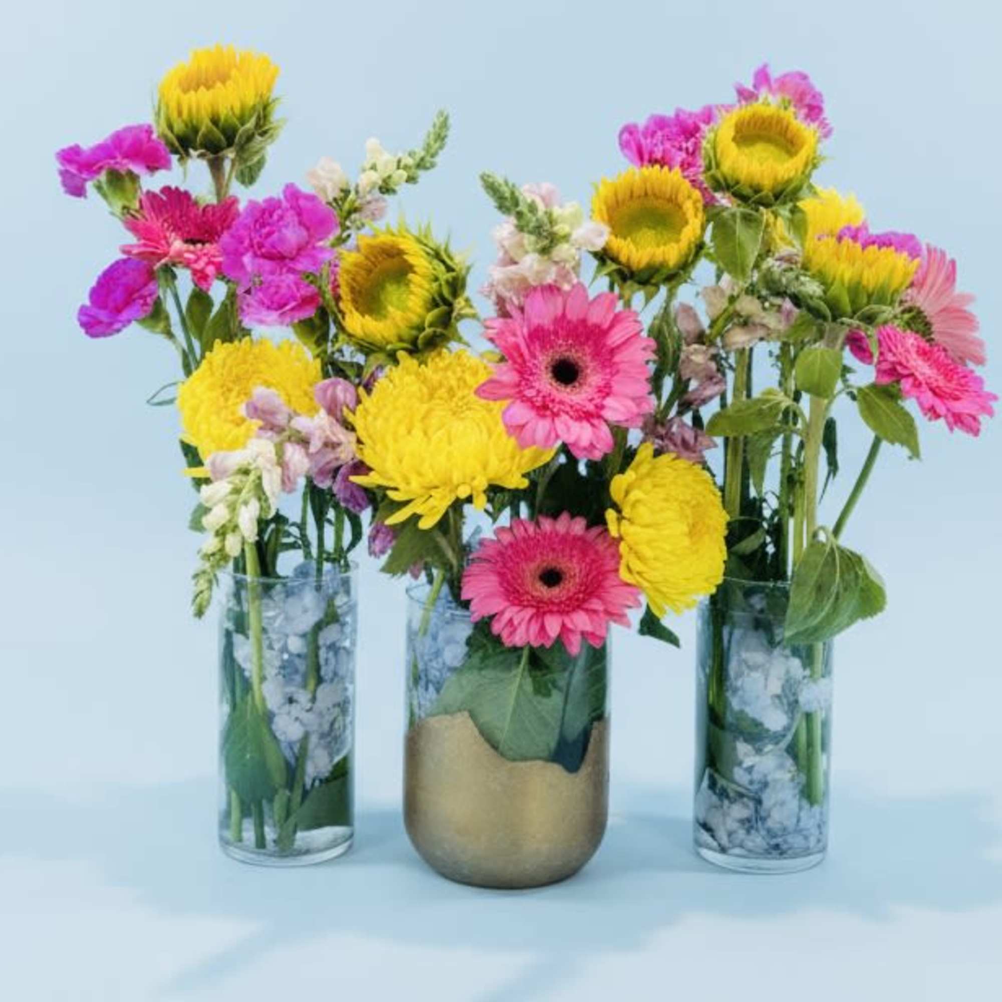 Hot pink gerbera daisies meet sunny yellow sunflowers and cheerful chrysanthemums 