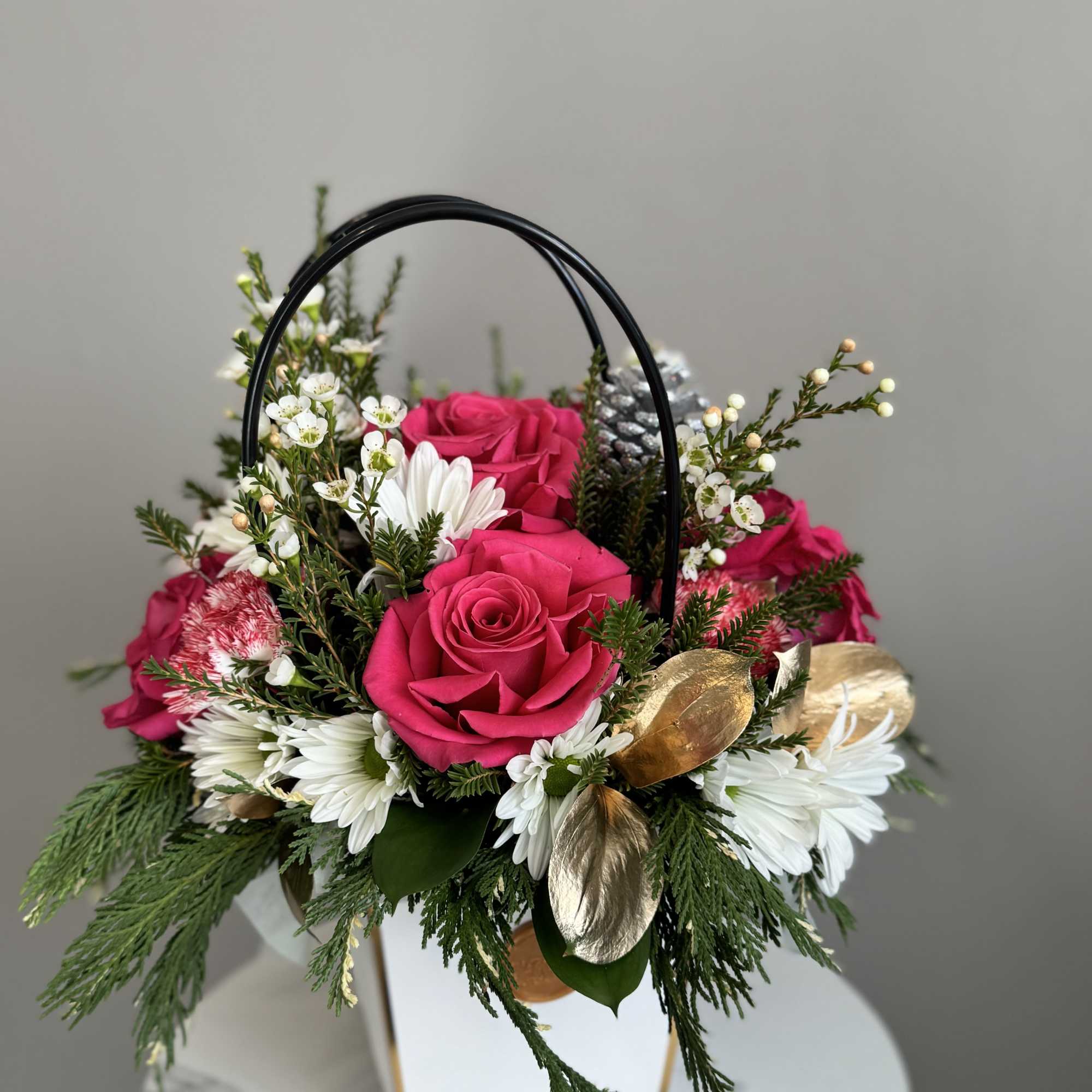 Pink roses and white daisies in a white handled box with gold accents
