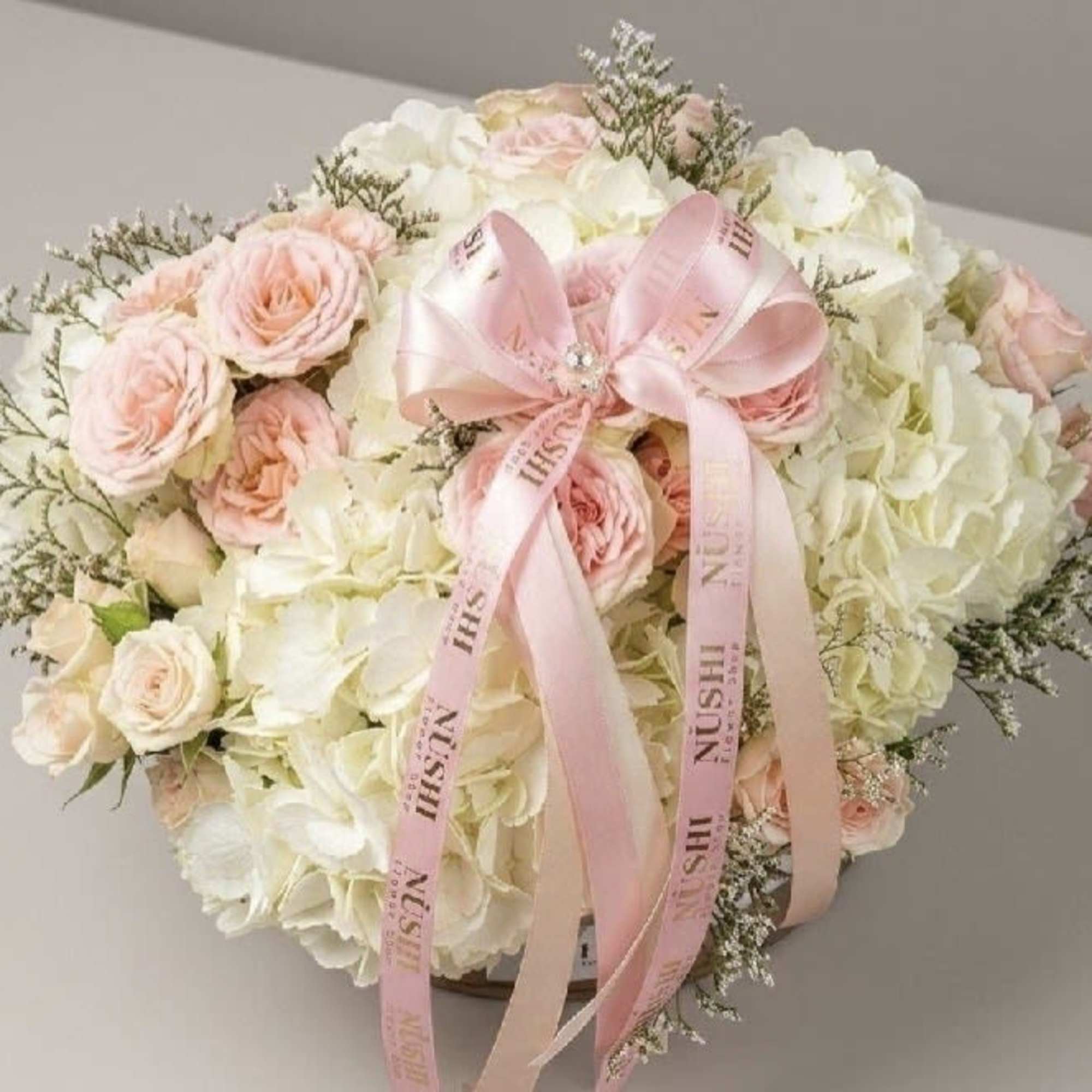 A timeless and elegant basket filled with fresh pink and white roses
