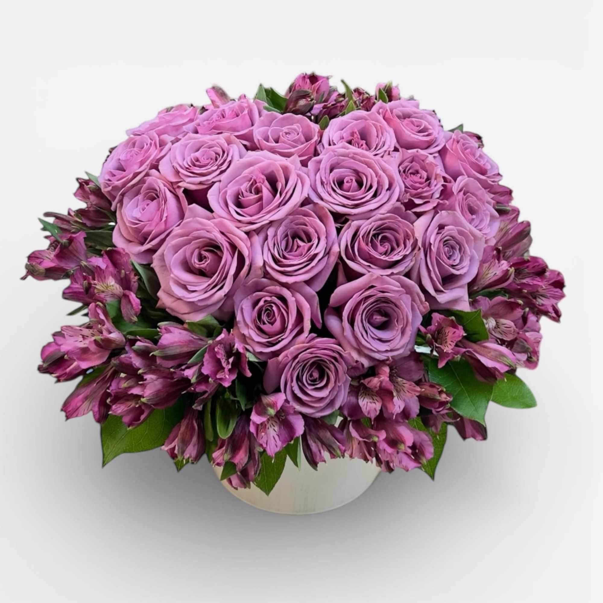 Pink roses and purple alstroemeria in a round white vase