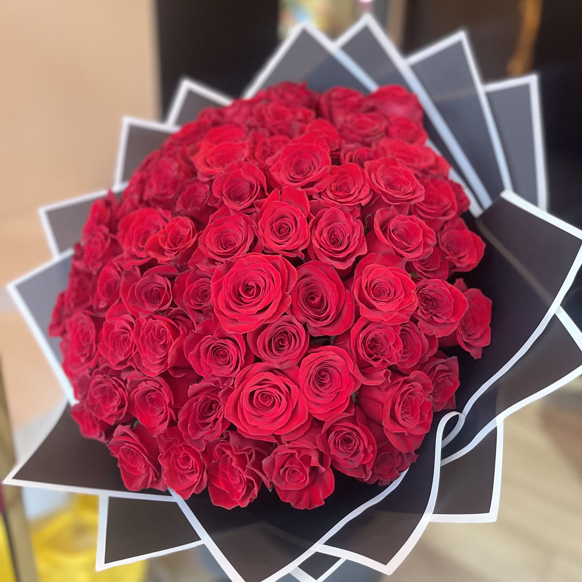 Large bouquet of red roses wrapped in black paper