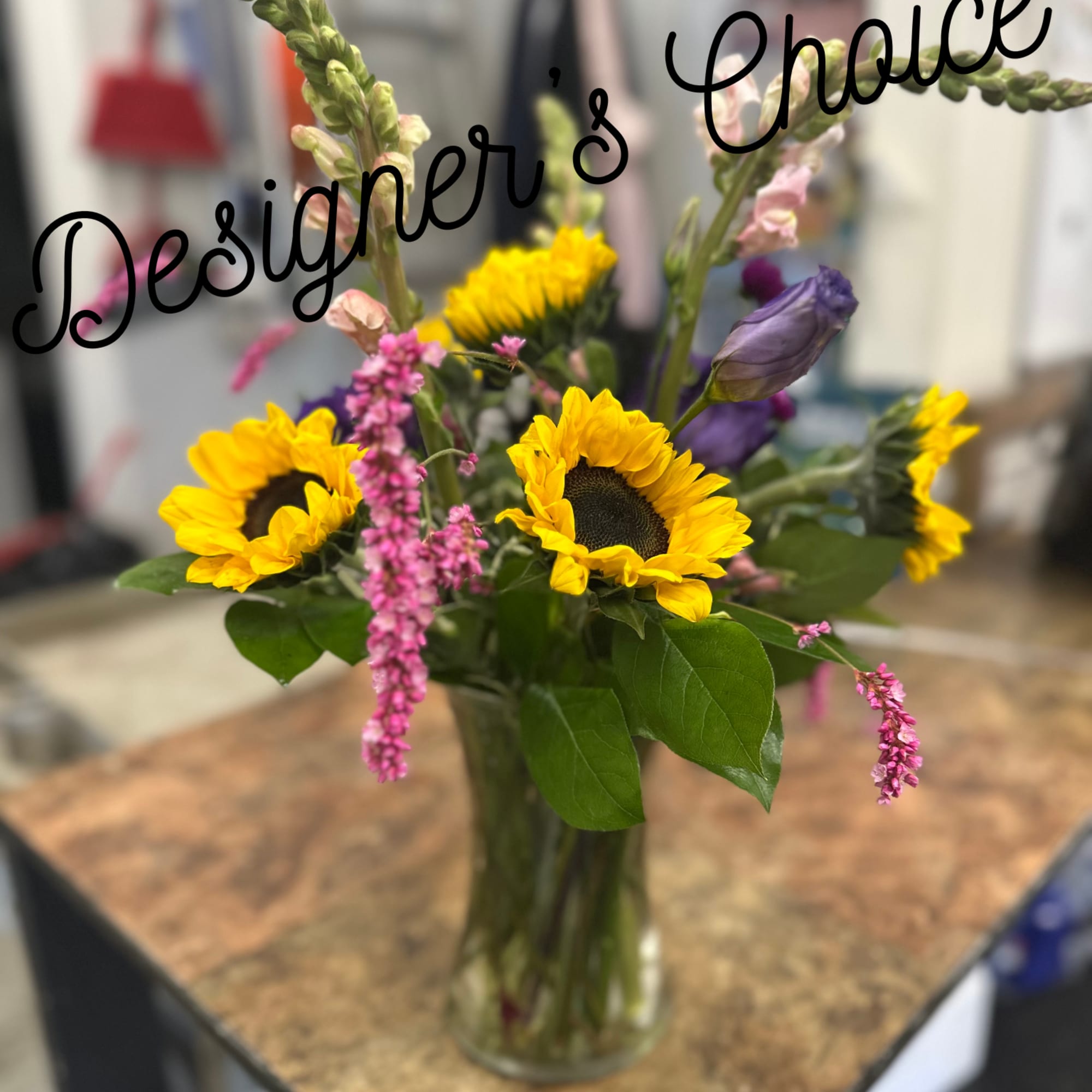 Sunflowers and pink filler flowers in a clear glass vase