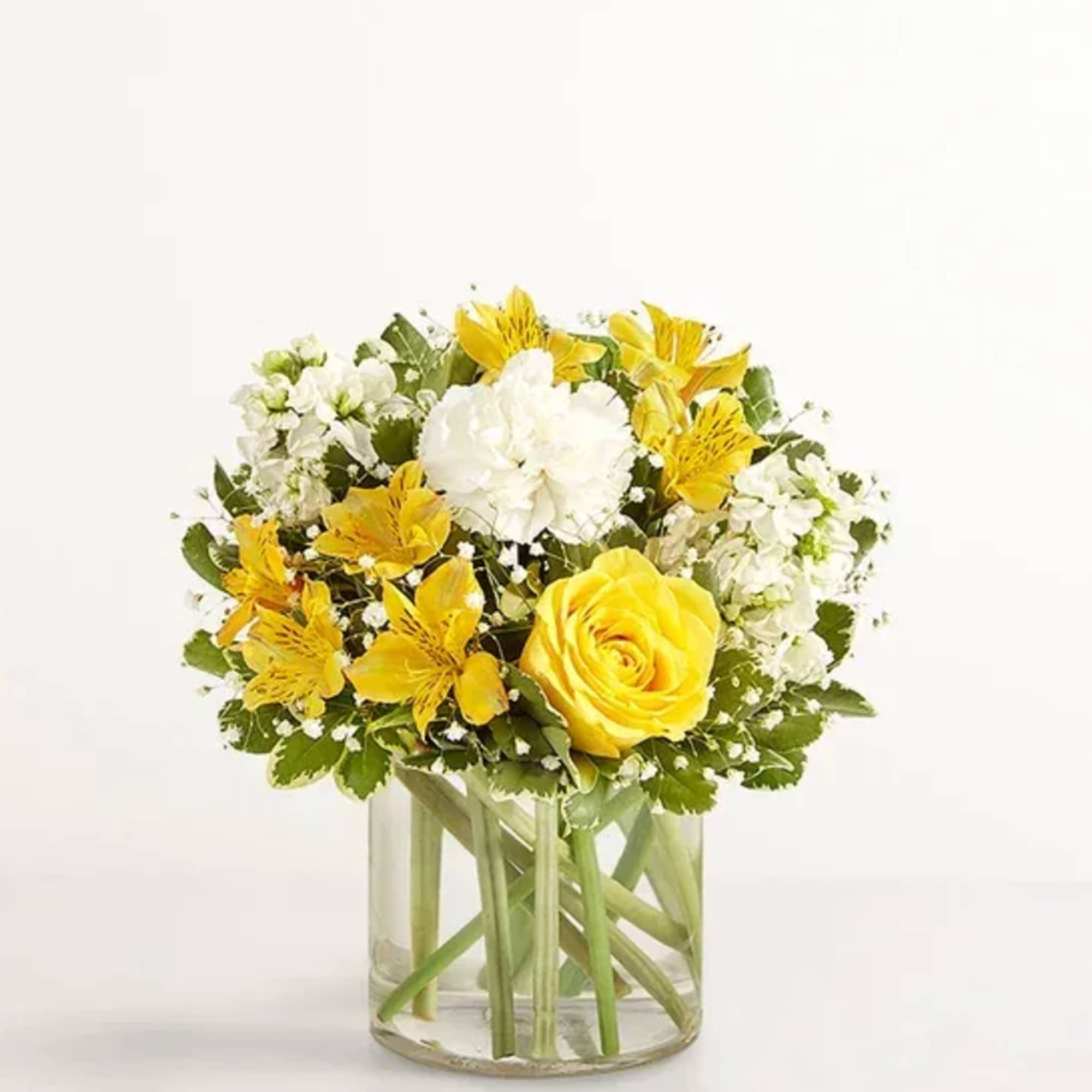 Yellow and white flower arrangement in a clear glass vase