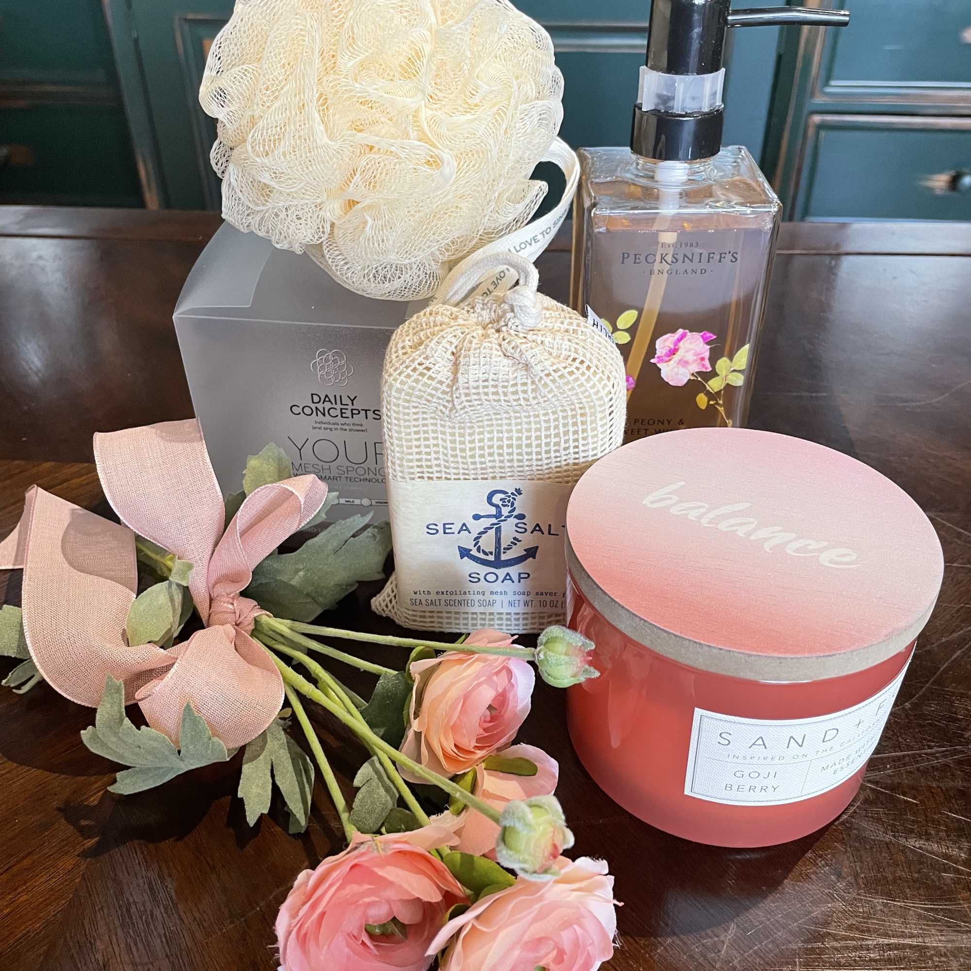 Spa gift set with pink flowers, soap, a candle, and a lotion bottle