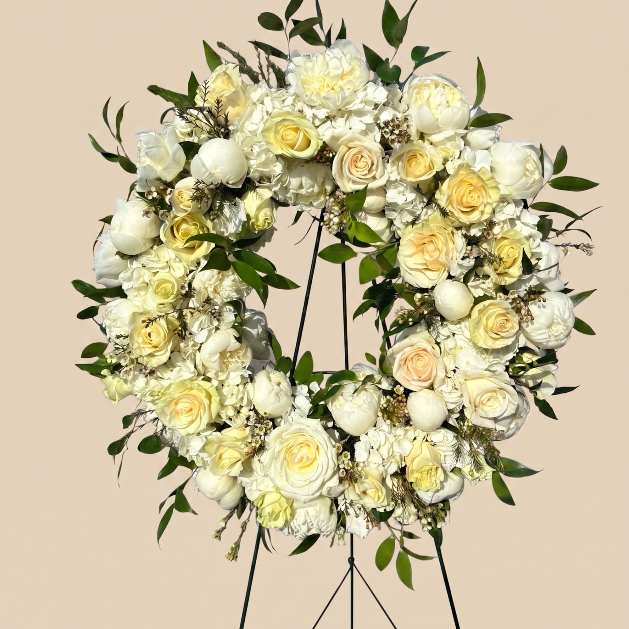 A textured standing wreath featuring of creamy whites and soft pale yellows.