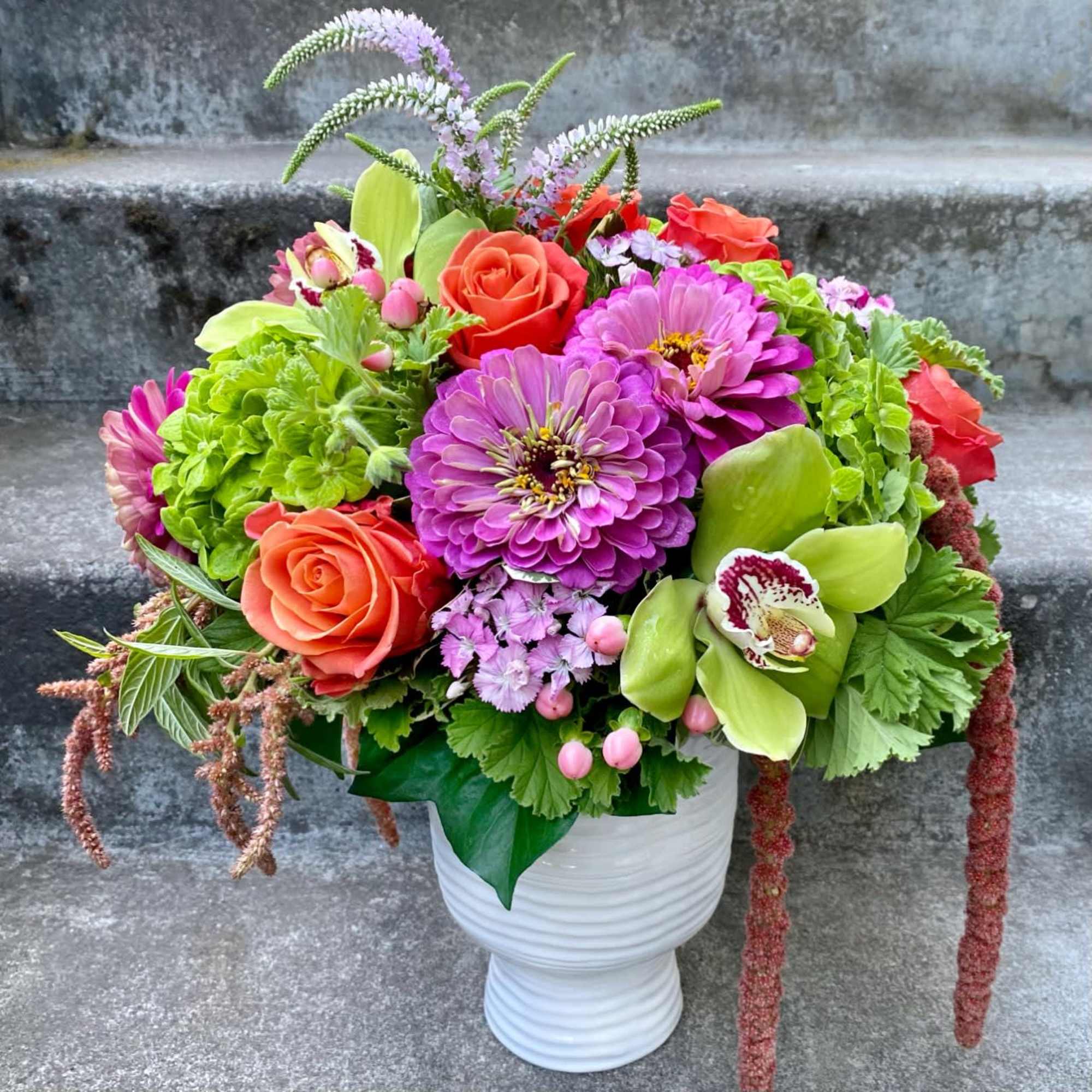 A Designer's Choice mixed floral arrangement that features summer flowers like dahlias