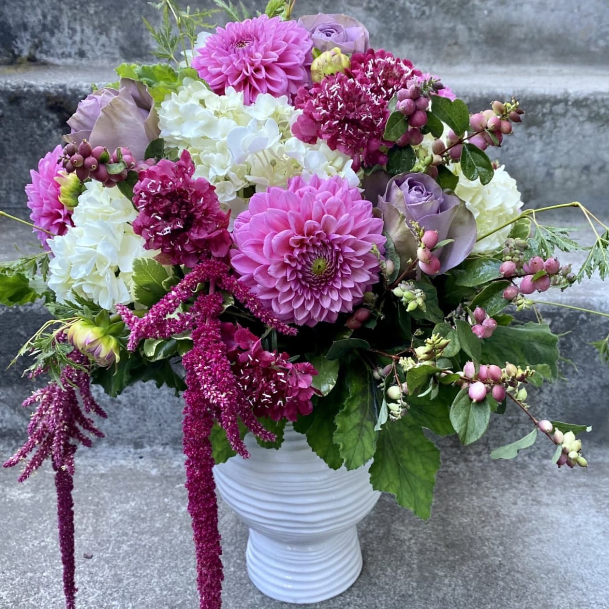 A Designer's Choice mixed floral arrangement that features summer flowers like dahlias