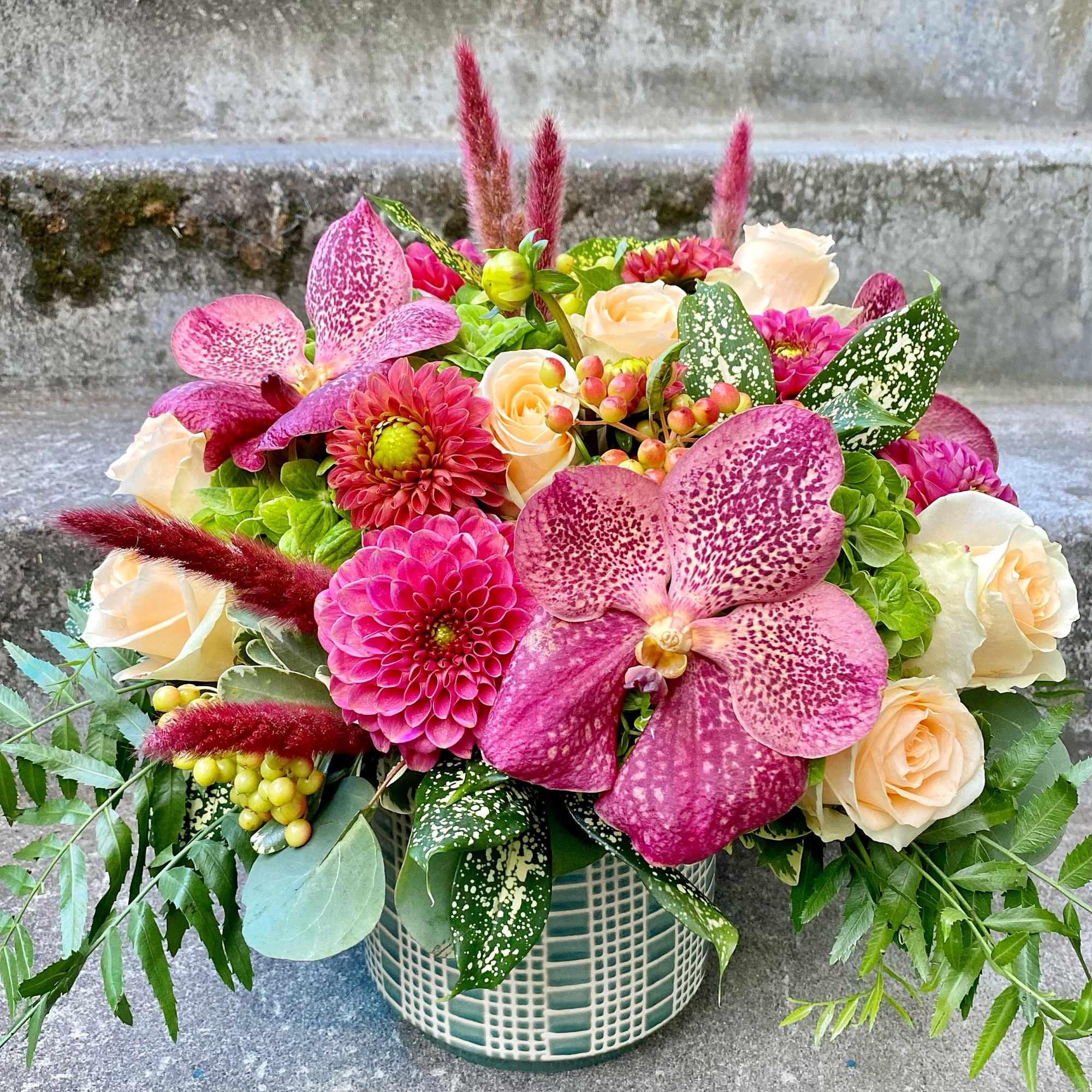 A Designer's Choice mixed floral arrangement that features summer flowers like dahlias