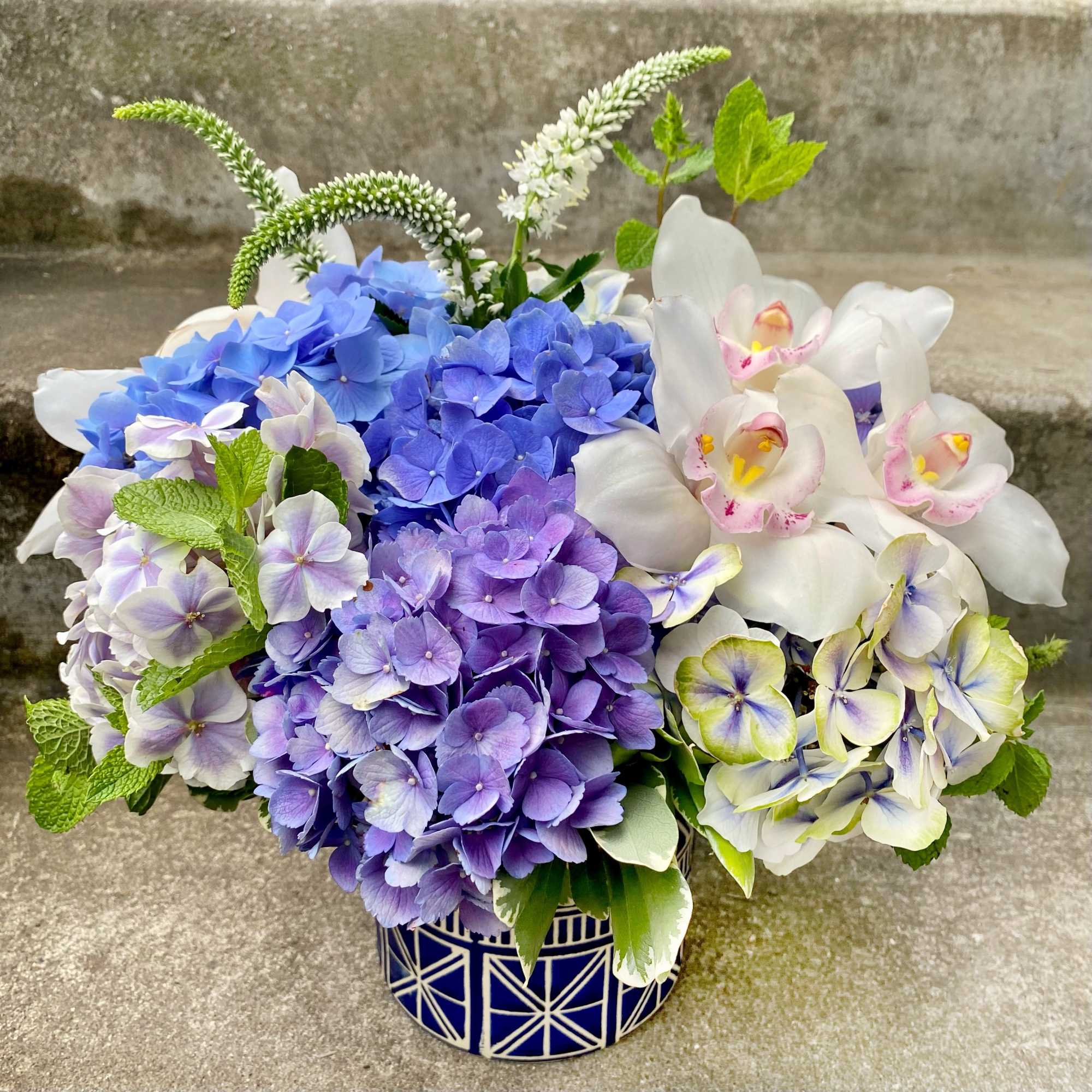 Blue and white floral arrangement in a patterned ceramic vase