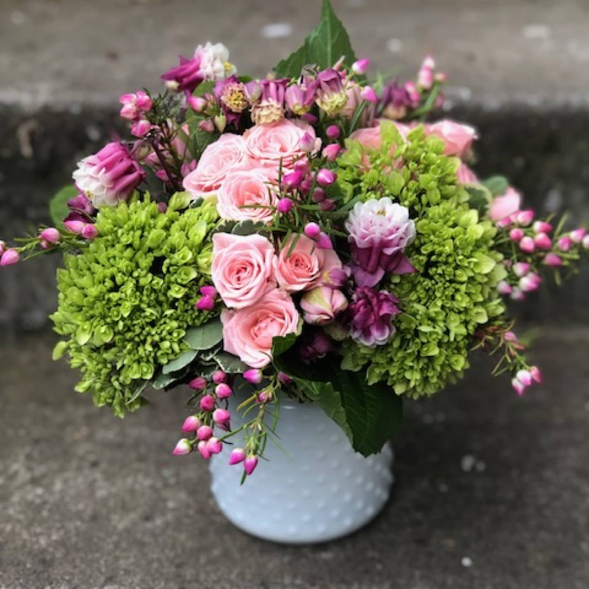 Pink roses and green hydrangeas in a white vase